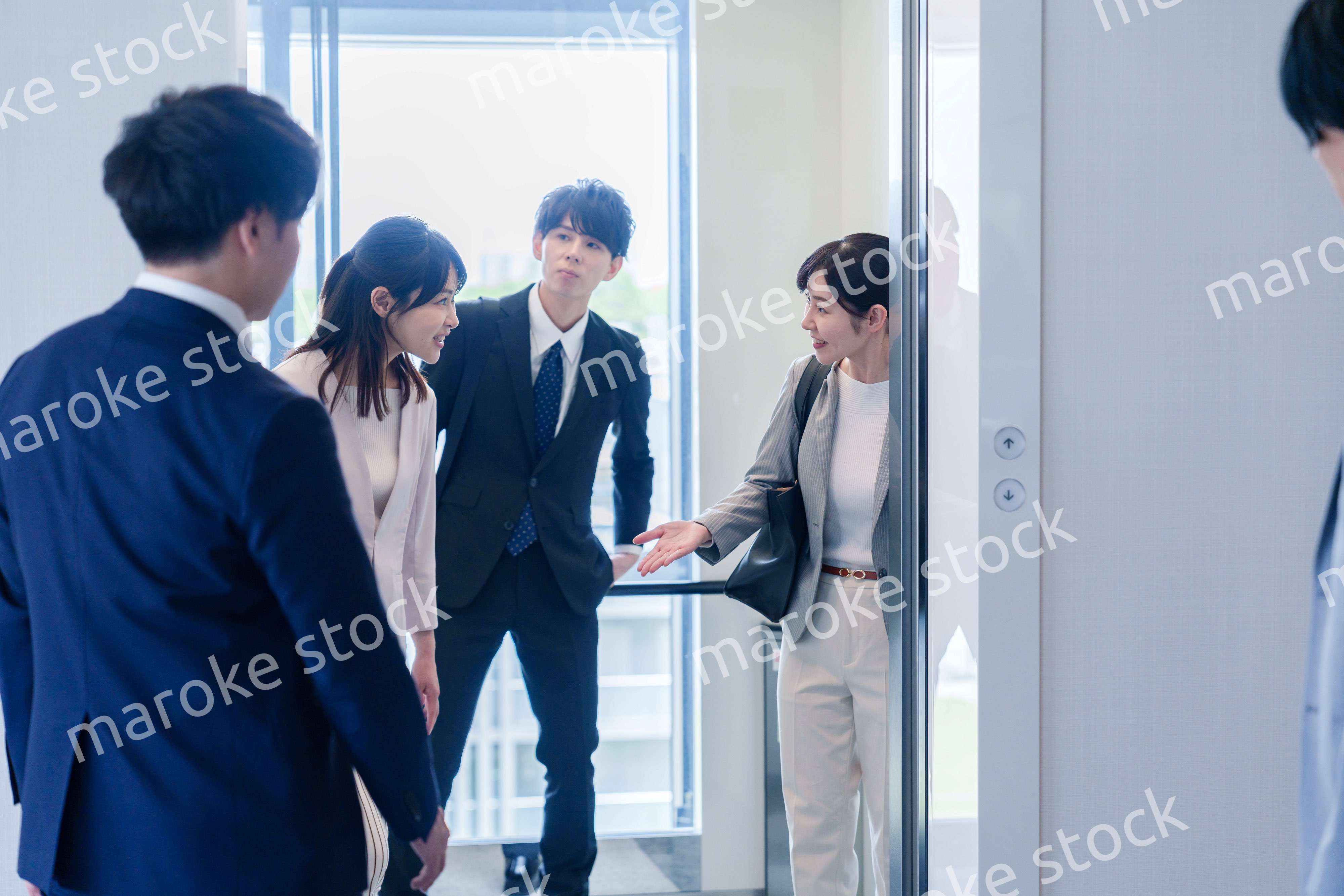 オフィスでエレベーターに乗るビジネスパーソン