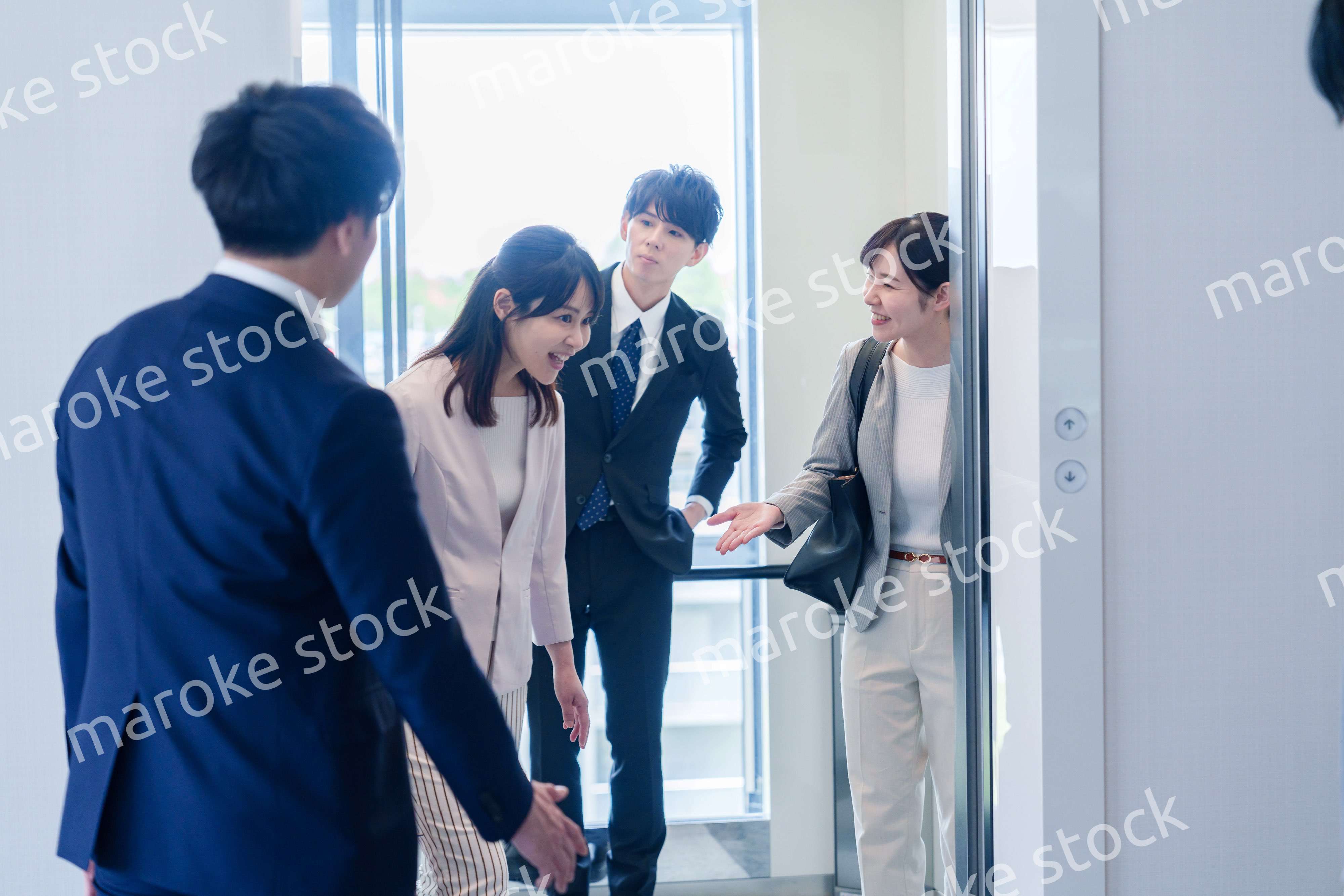 オフィスでエレベーターに乗るビジネスパーソン