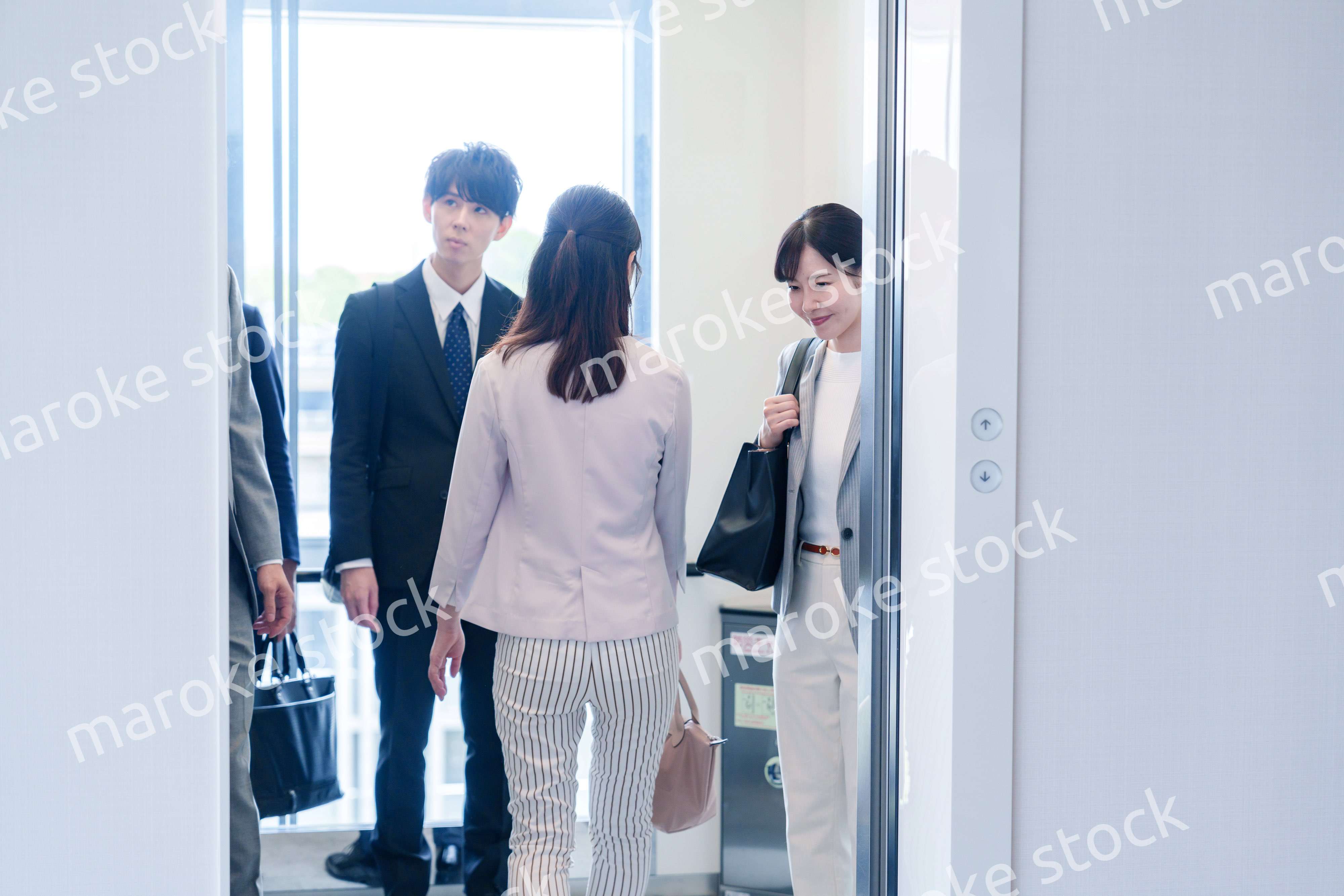 オフィスでエレベーターに乗るビジネスパーソン
