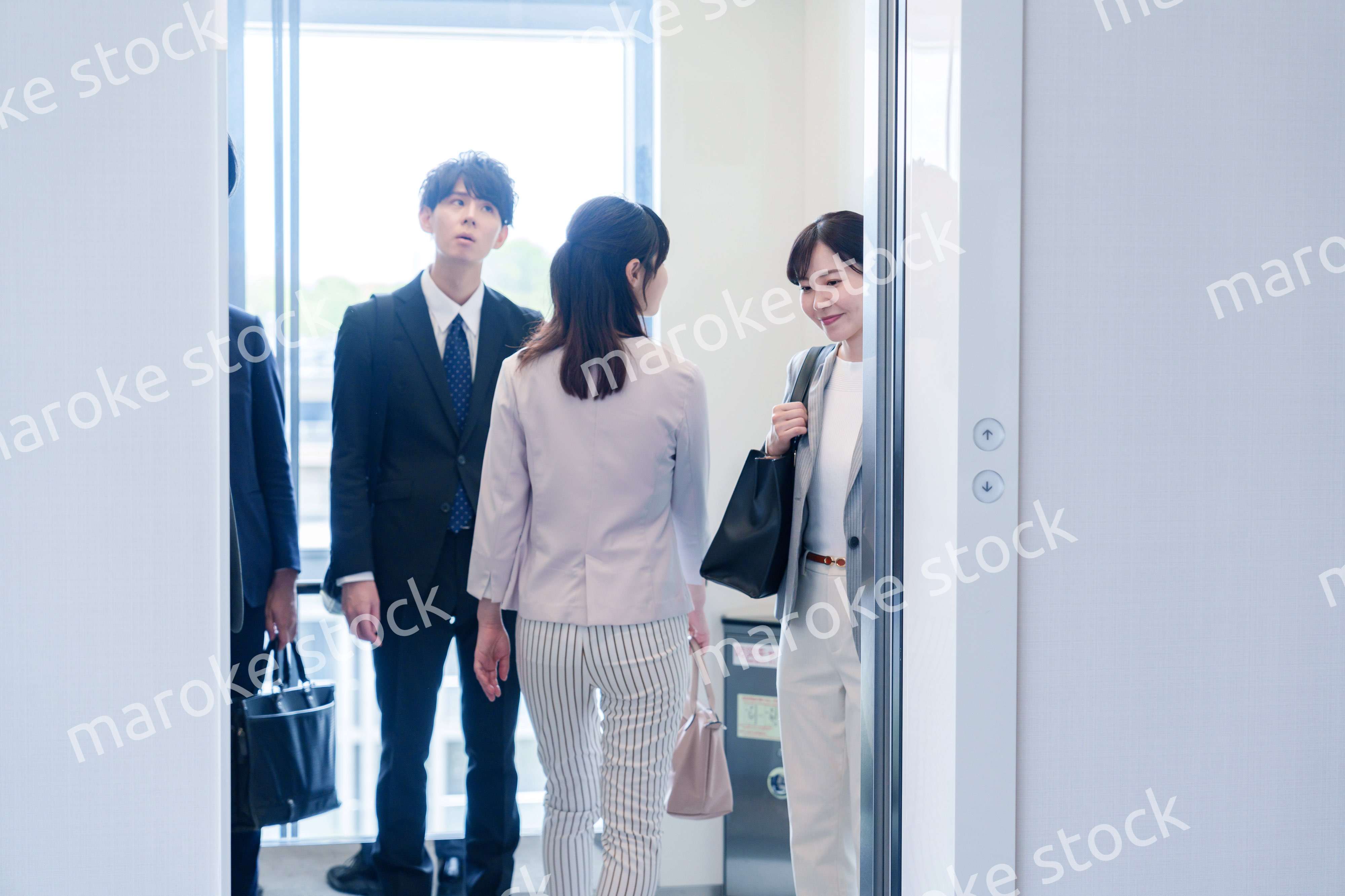 オフィスでエレベーターに乗るビジネスパーソン