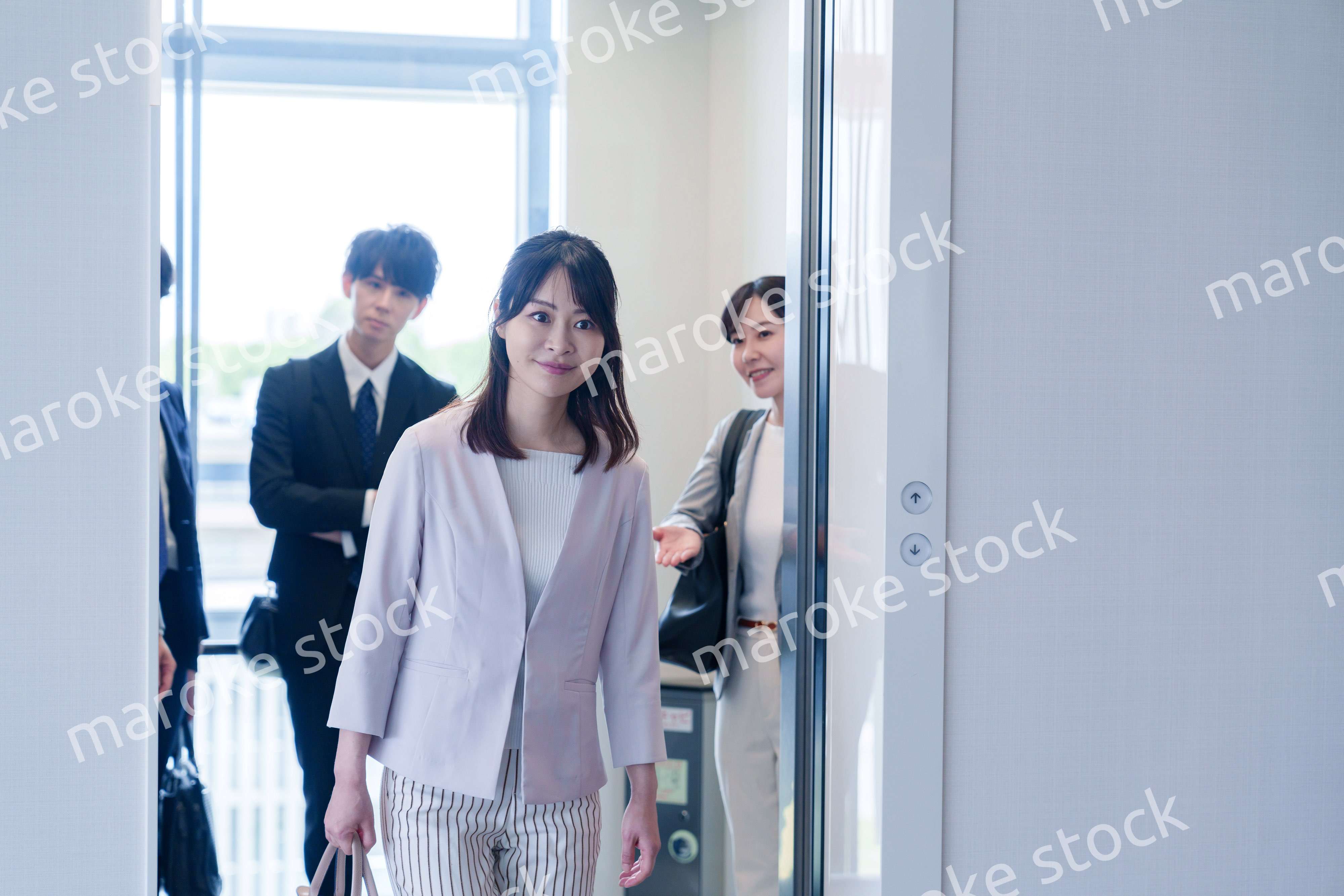 オフィスでエレベーターに乗るビジネスパーソン