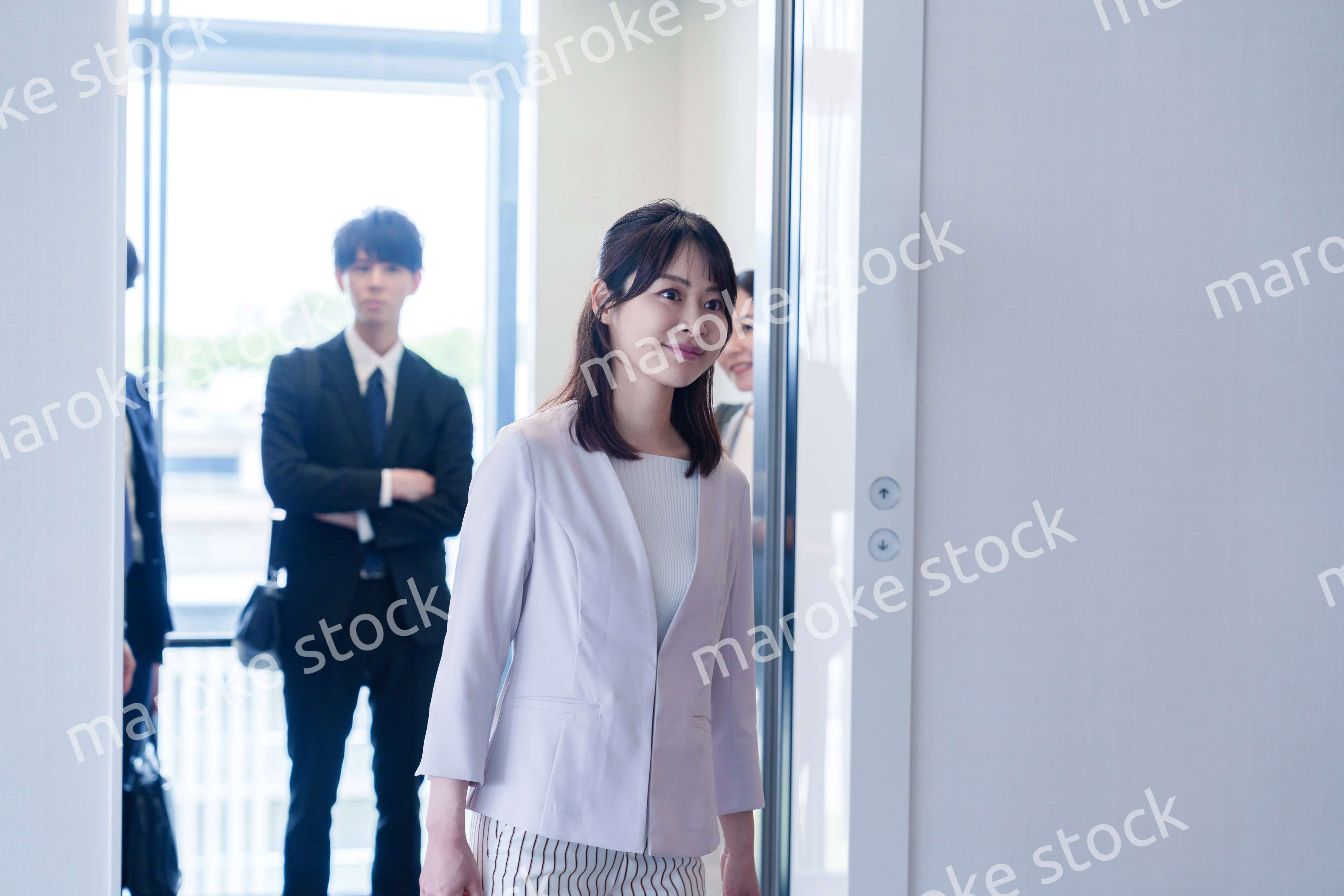 オフィスでエレベーターに乗るビジネスパーソン