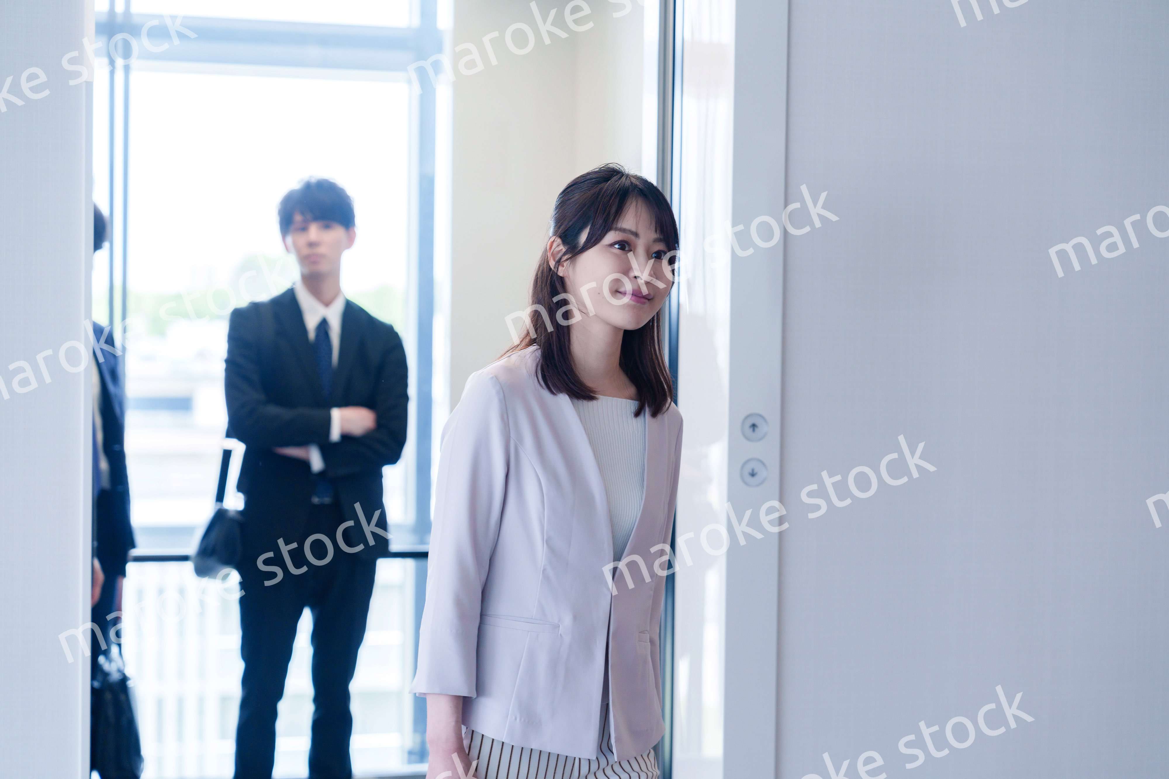 オフィスでエレベーターに乗るビジネスパーソン