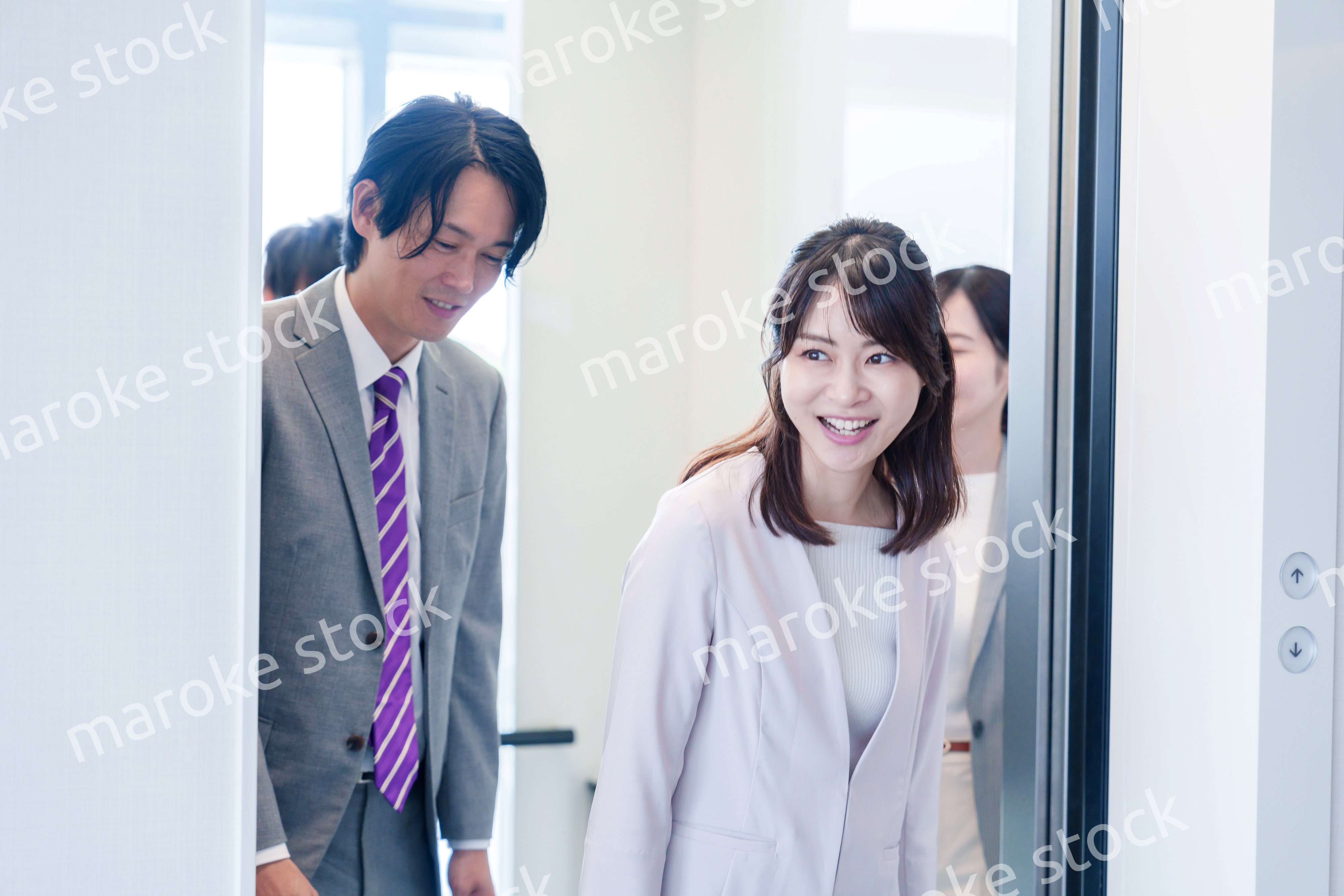 オフィスでエレベーターに乗るビジネスパーソン