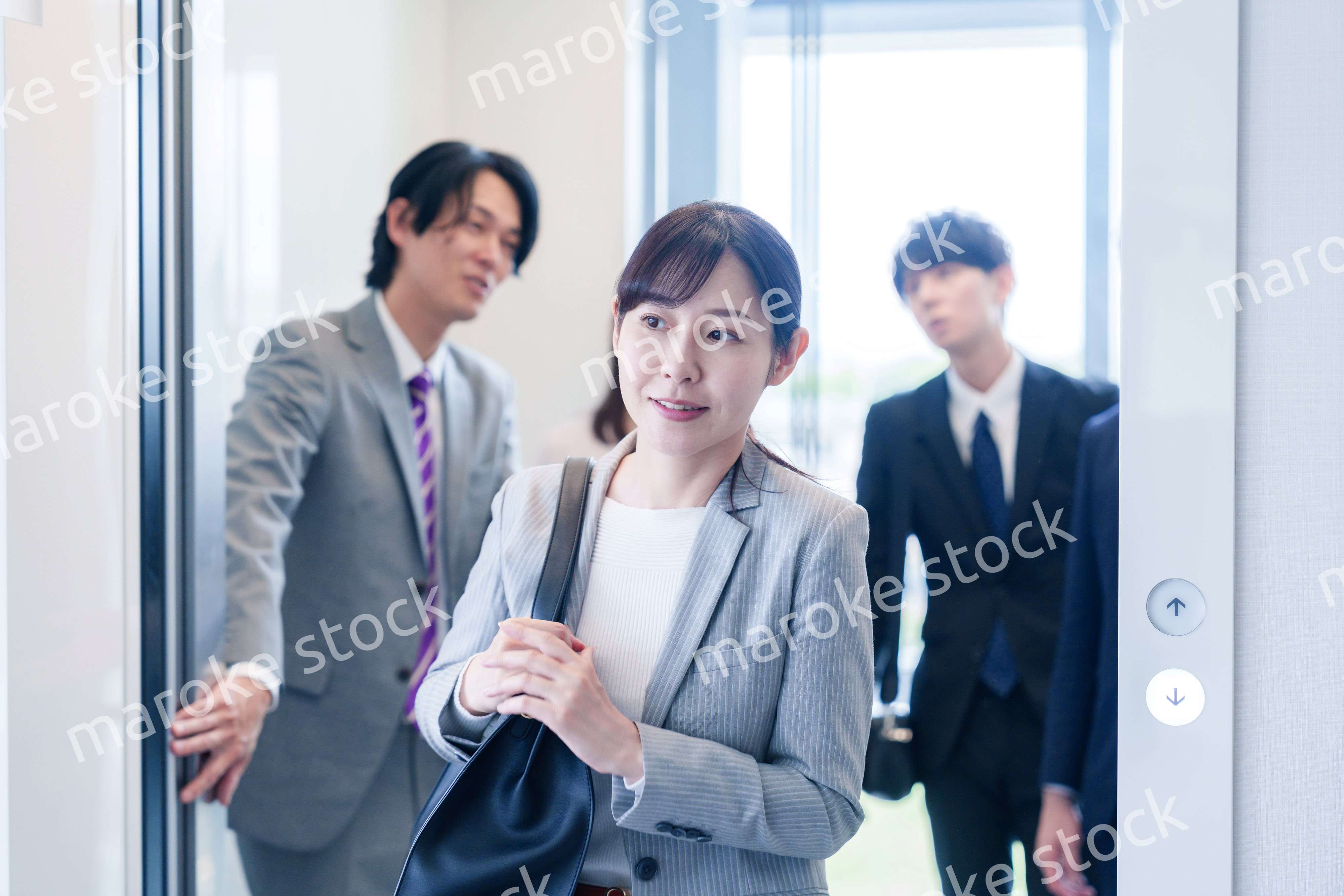 オフィスでエレベーターに乗るビジネスパーソン