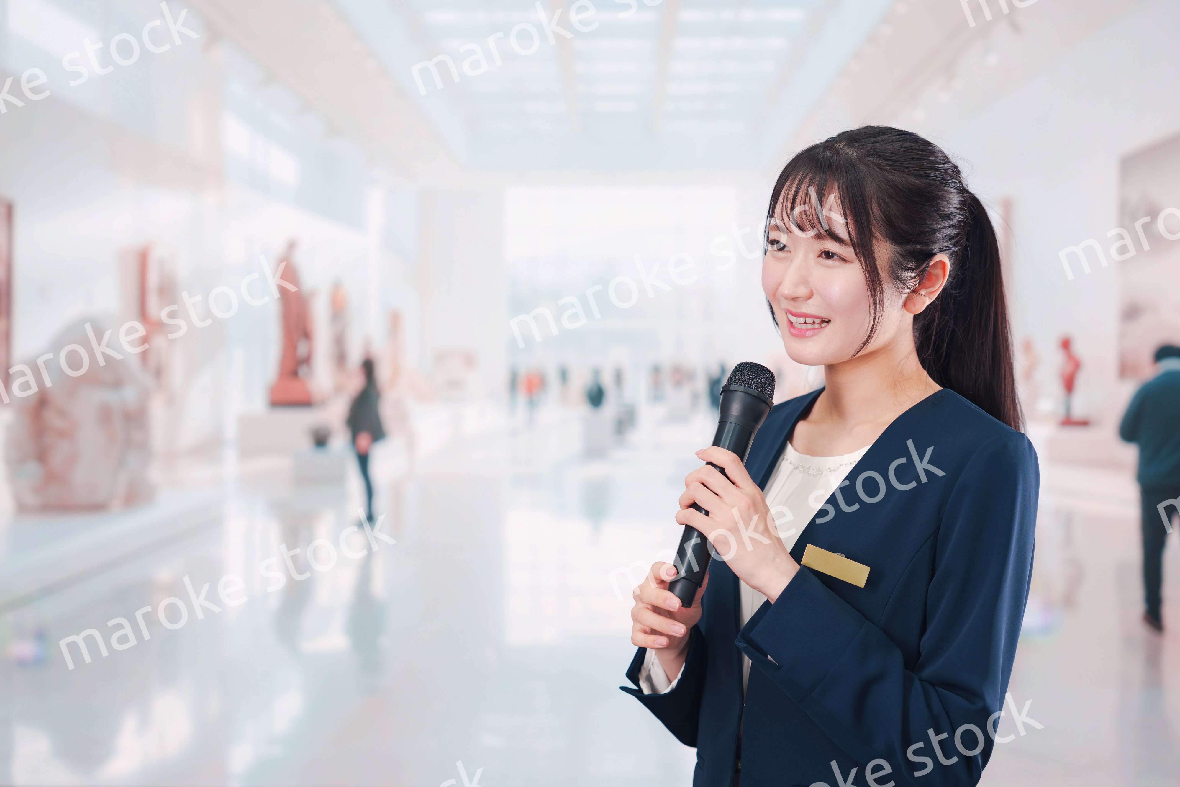 博物館で司会をする学芸員の女性