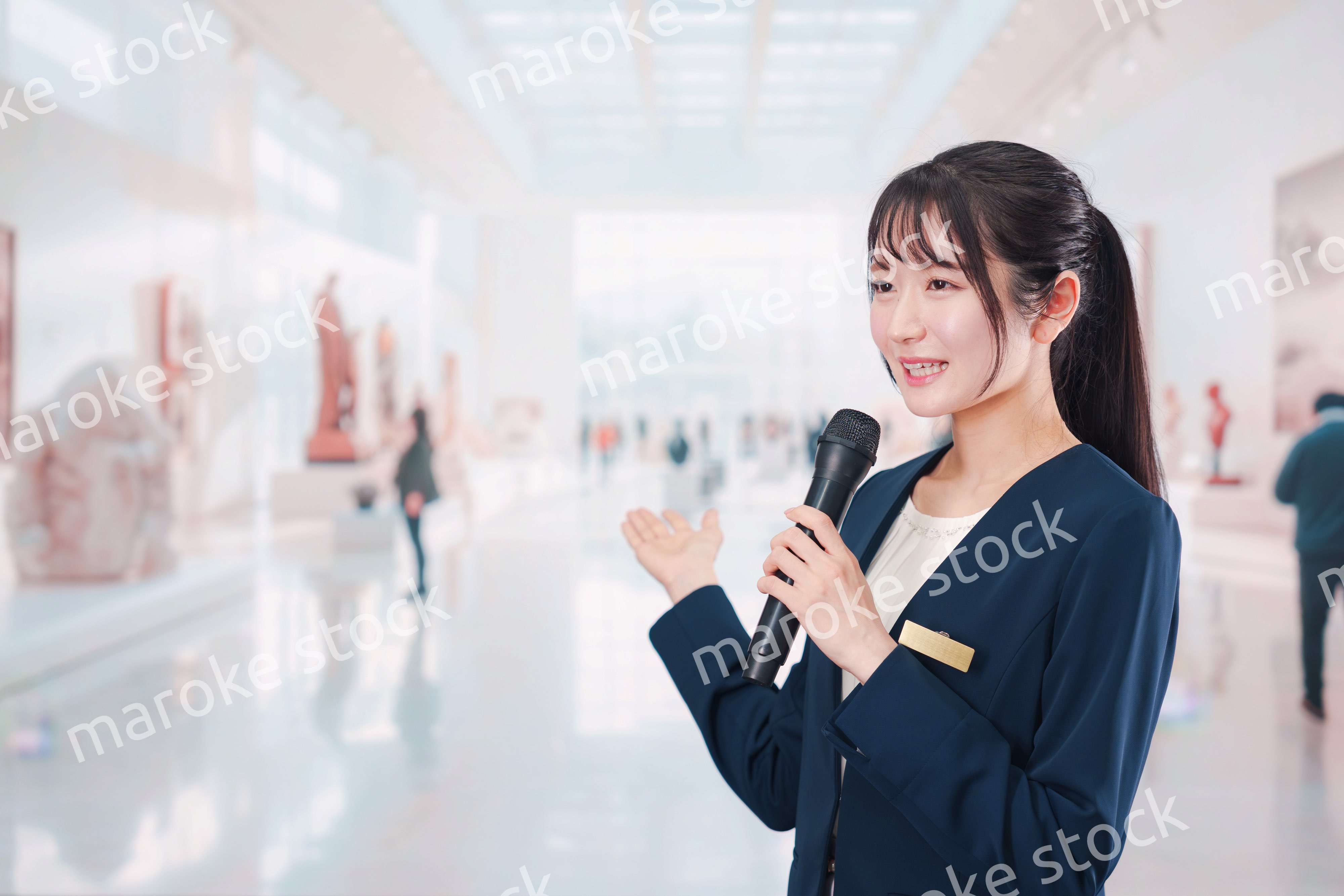 博物館で司会をする学芸員の女性