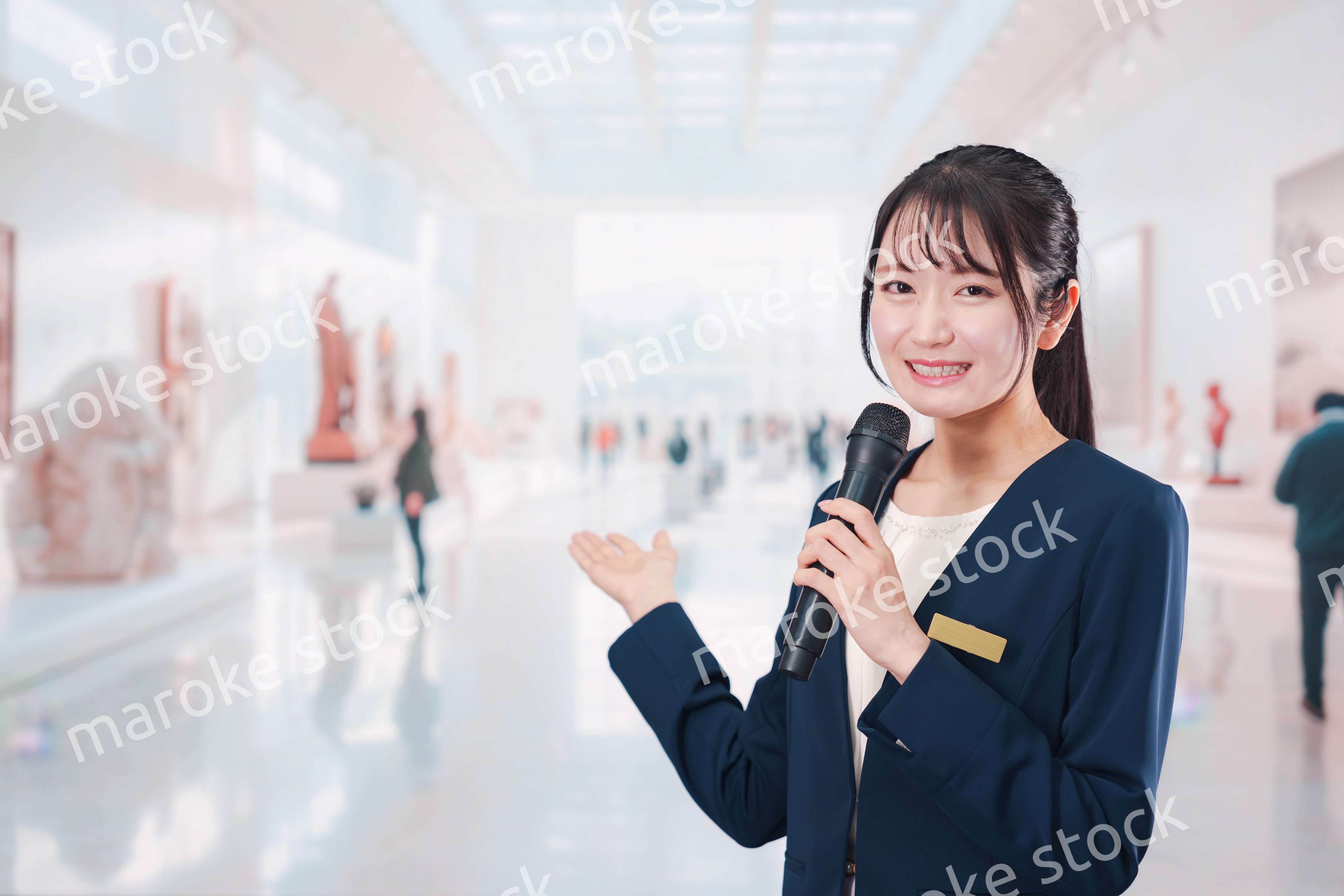 博物館で司会をする学芸員の女性