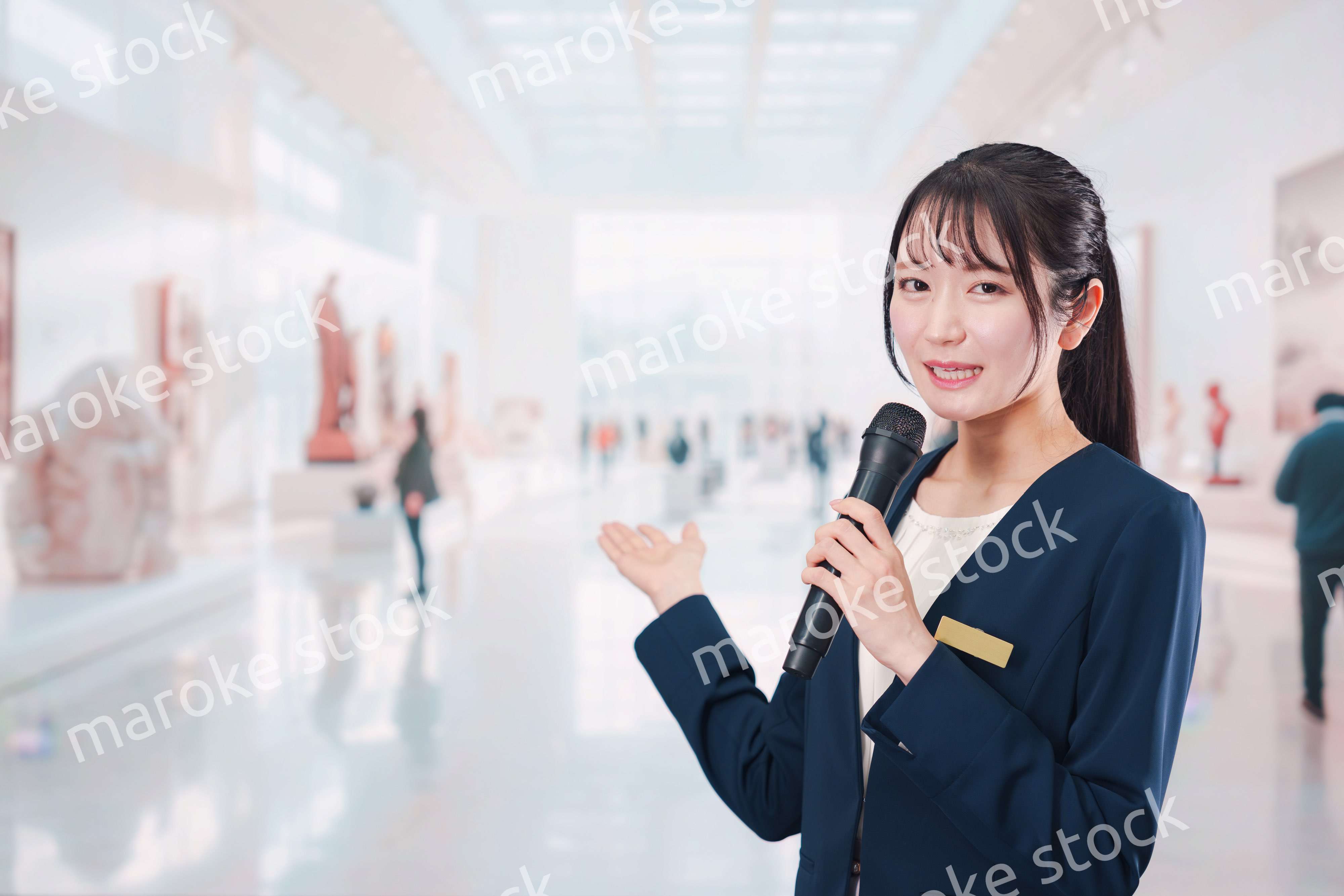 博物館で司会をする学芸員の女性