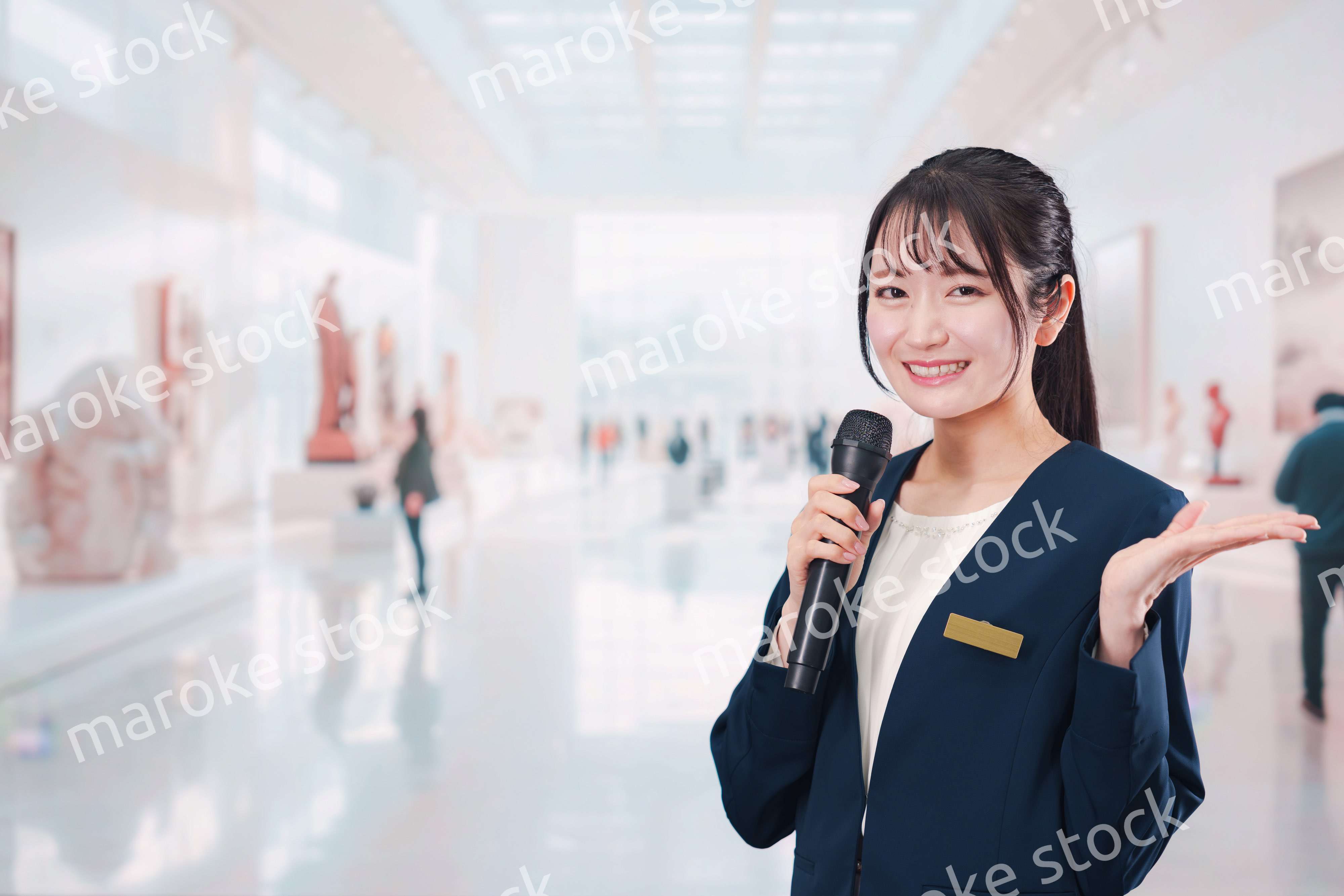 博物館で司会をする学芸員の女性
