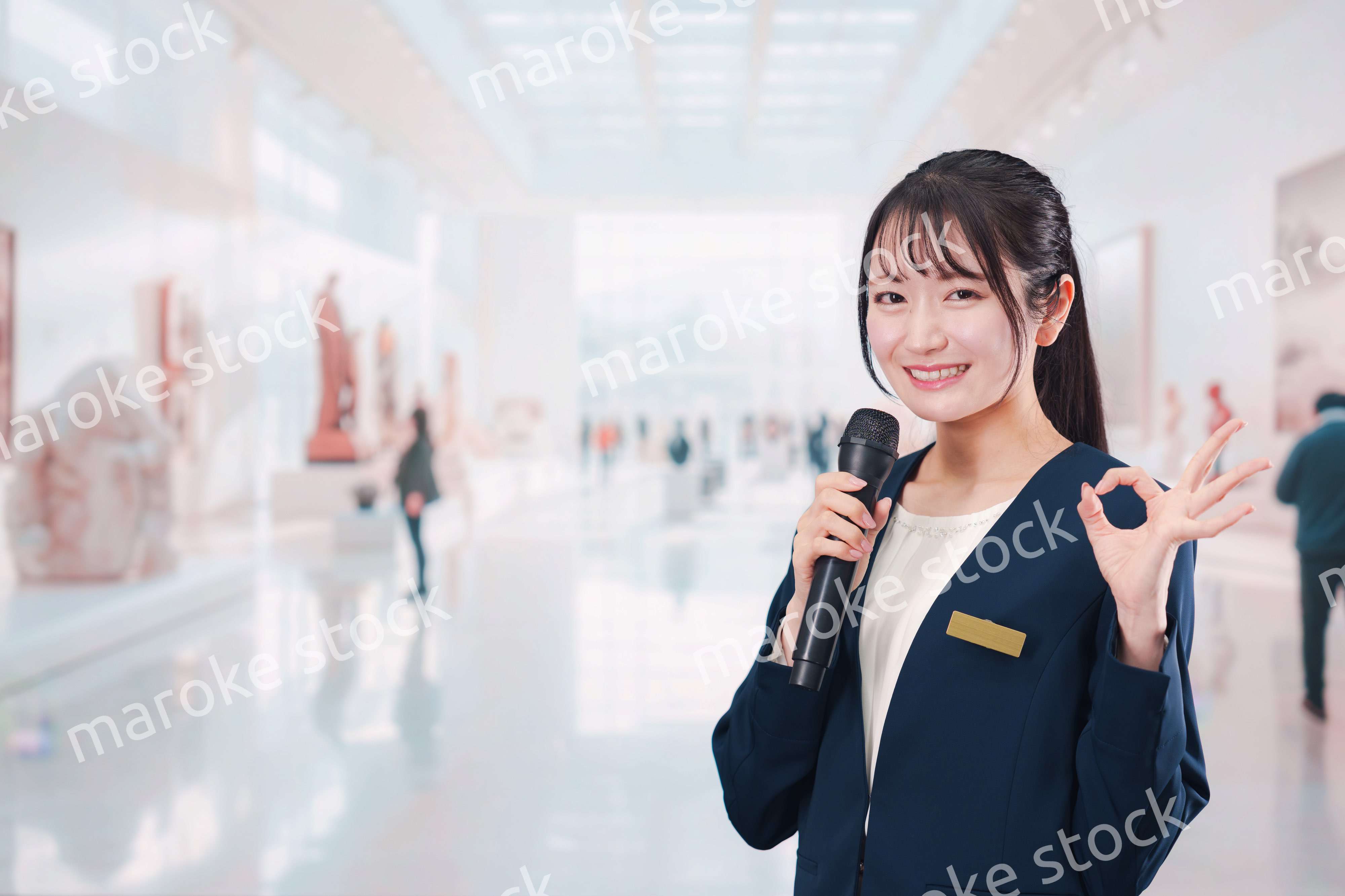 博物館で司会をする学芸員の女性