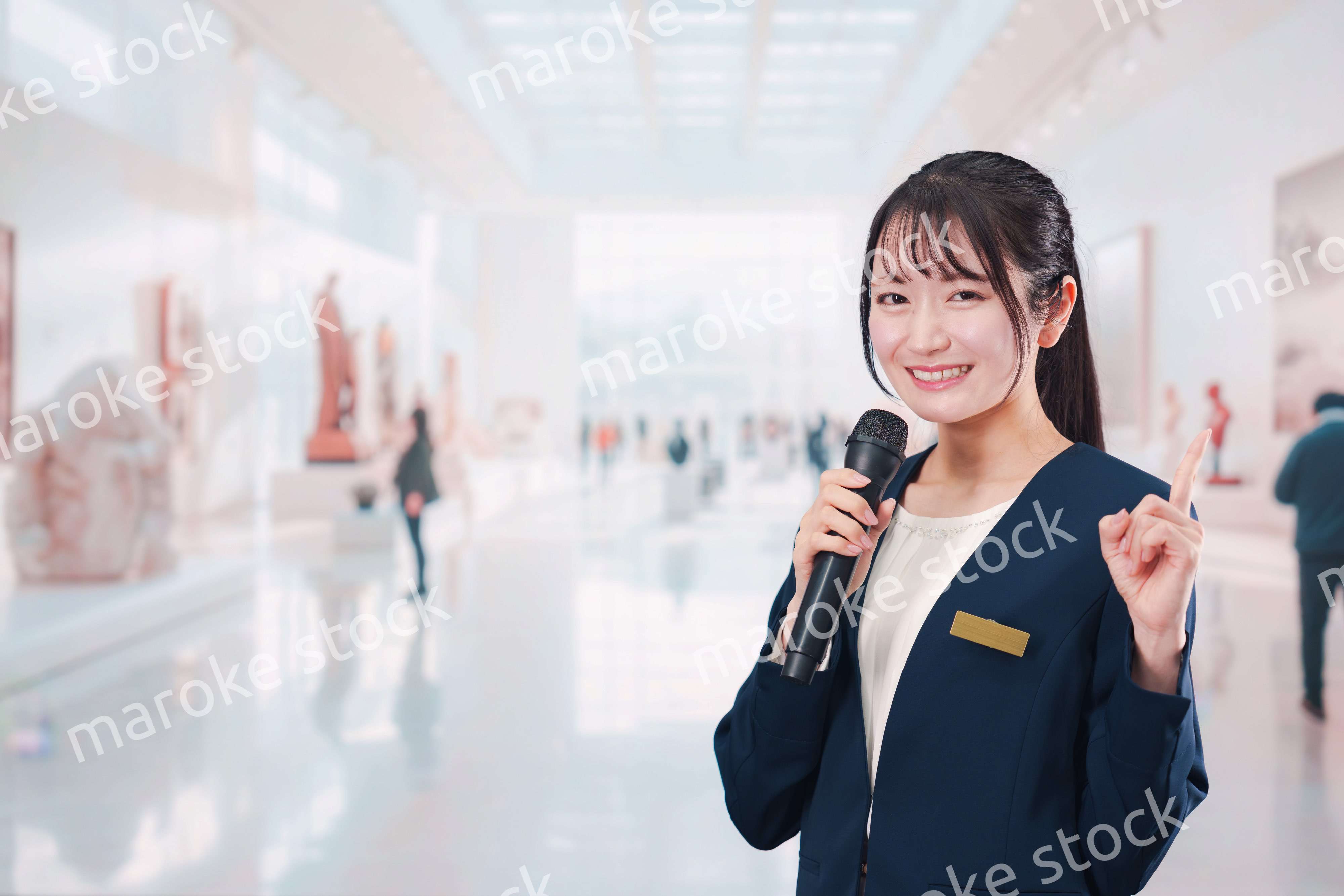 博物館で司会をする学芸員の女性