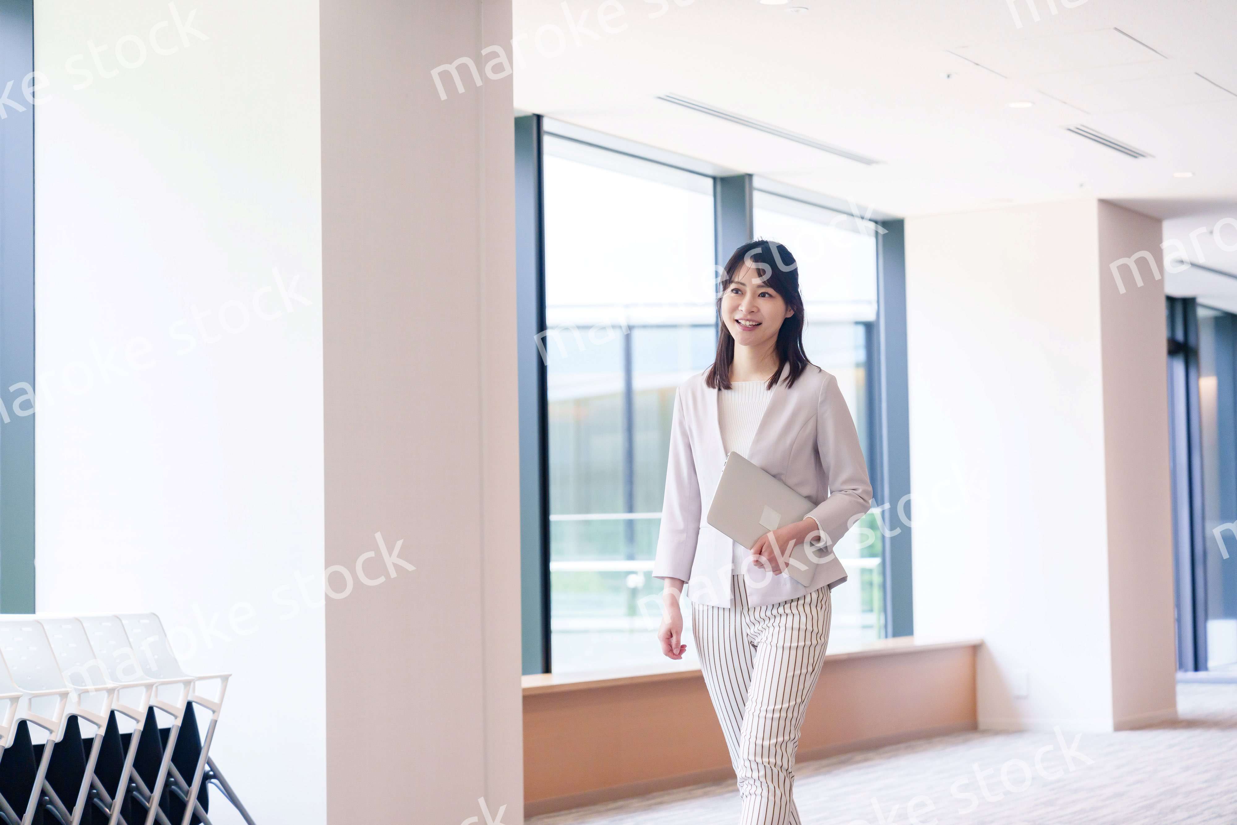 オフィスの中で笑顔で歩くビジネスウーマン