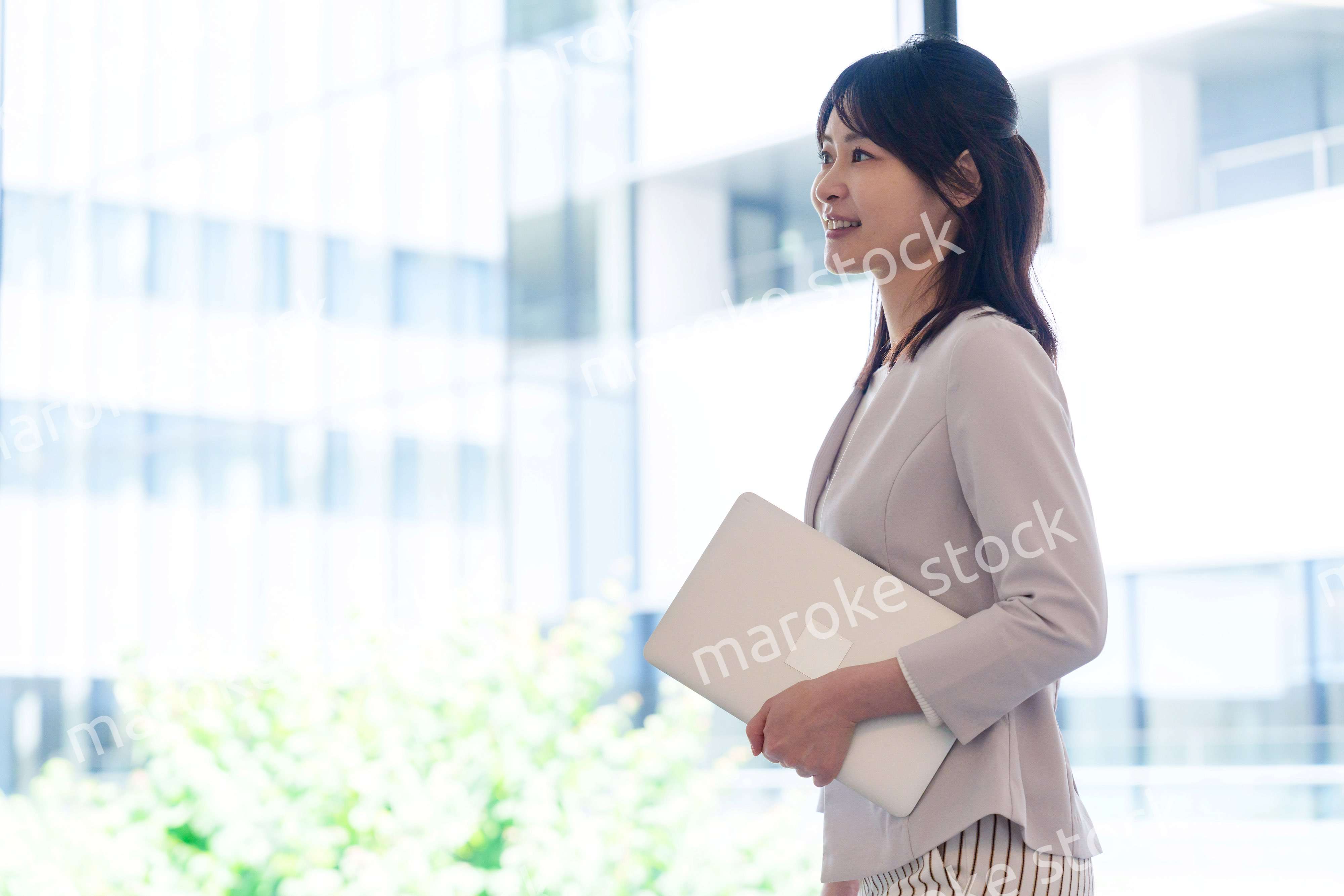 オフィスの中で笑顔で歩くビジネスウーマン