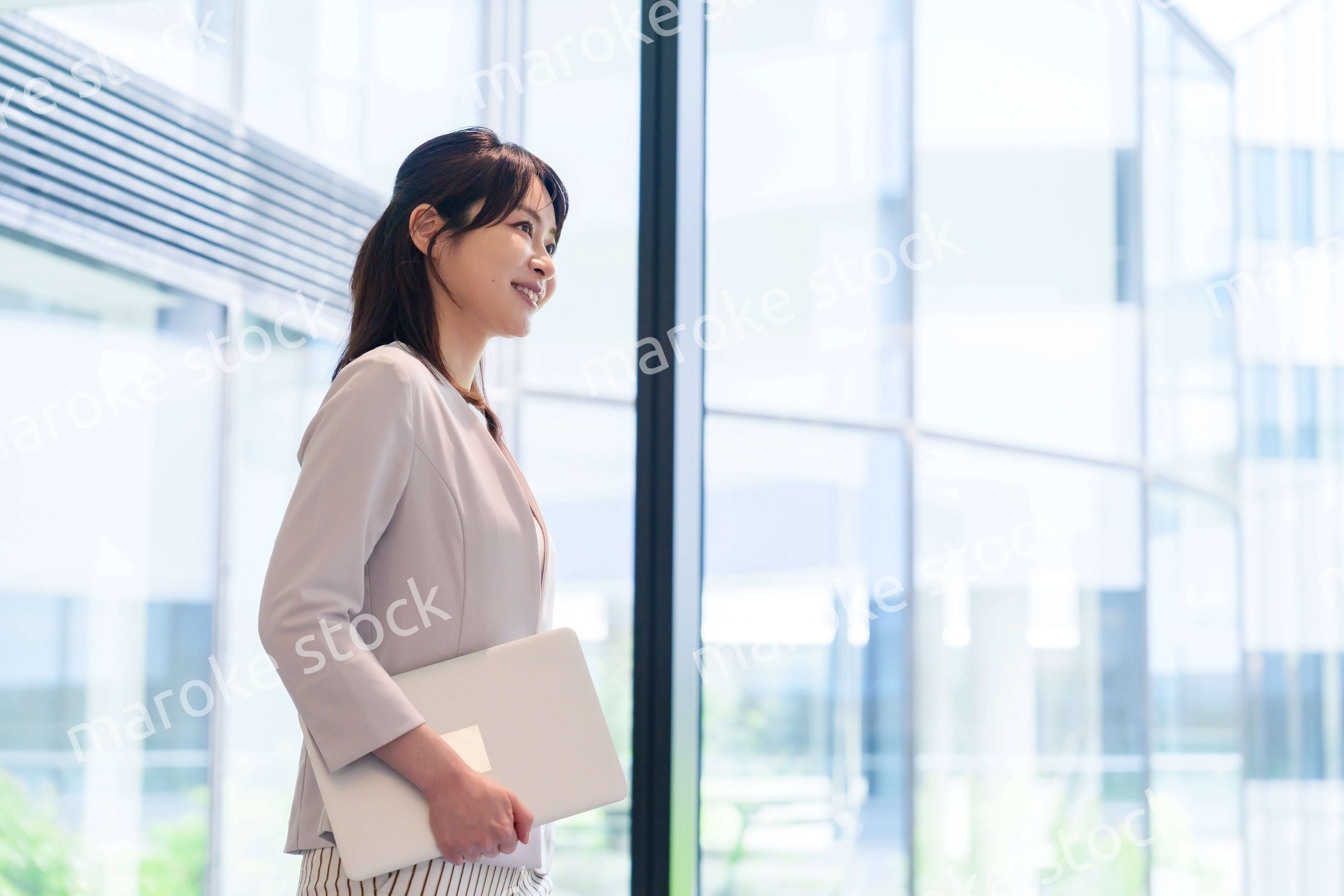 オフィスの中で笑顔で歩くビジネスウーマン