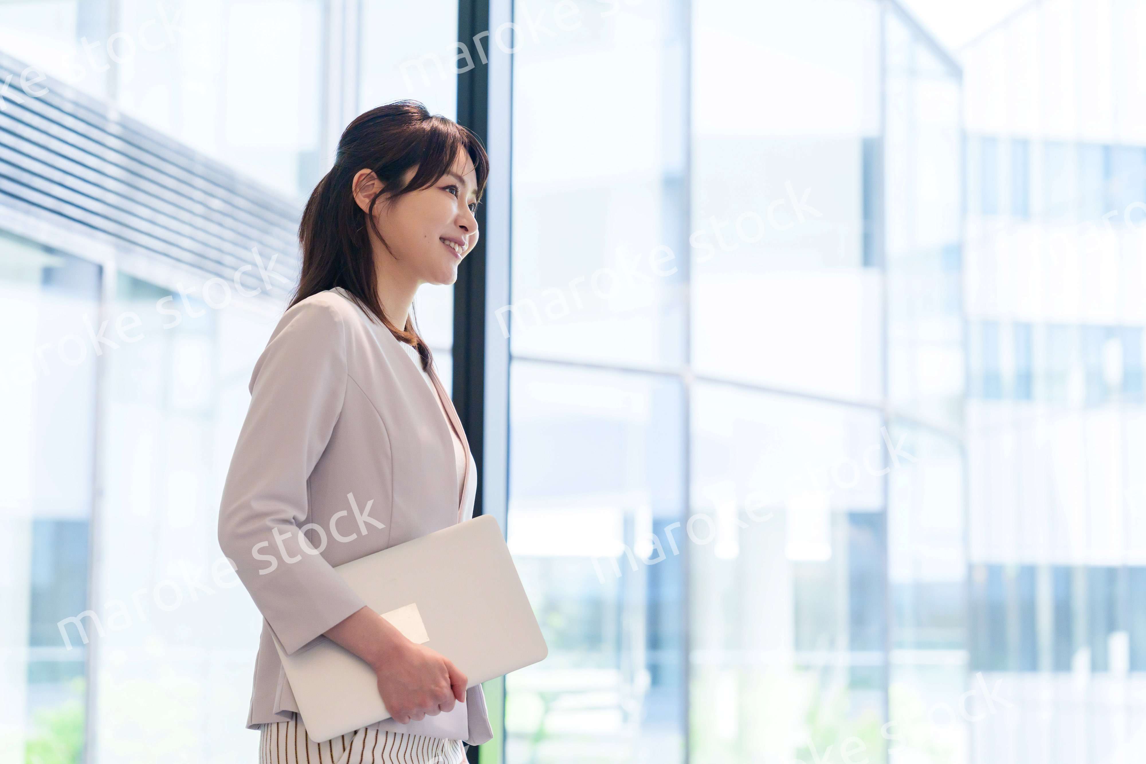 オフィスの中で笑顔で歩くビジネスウーマン