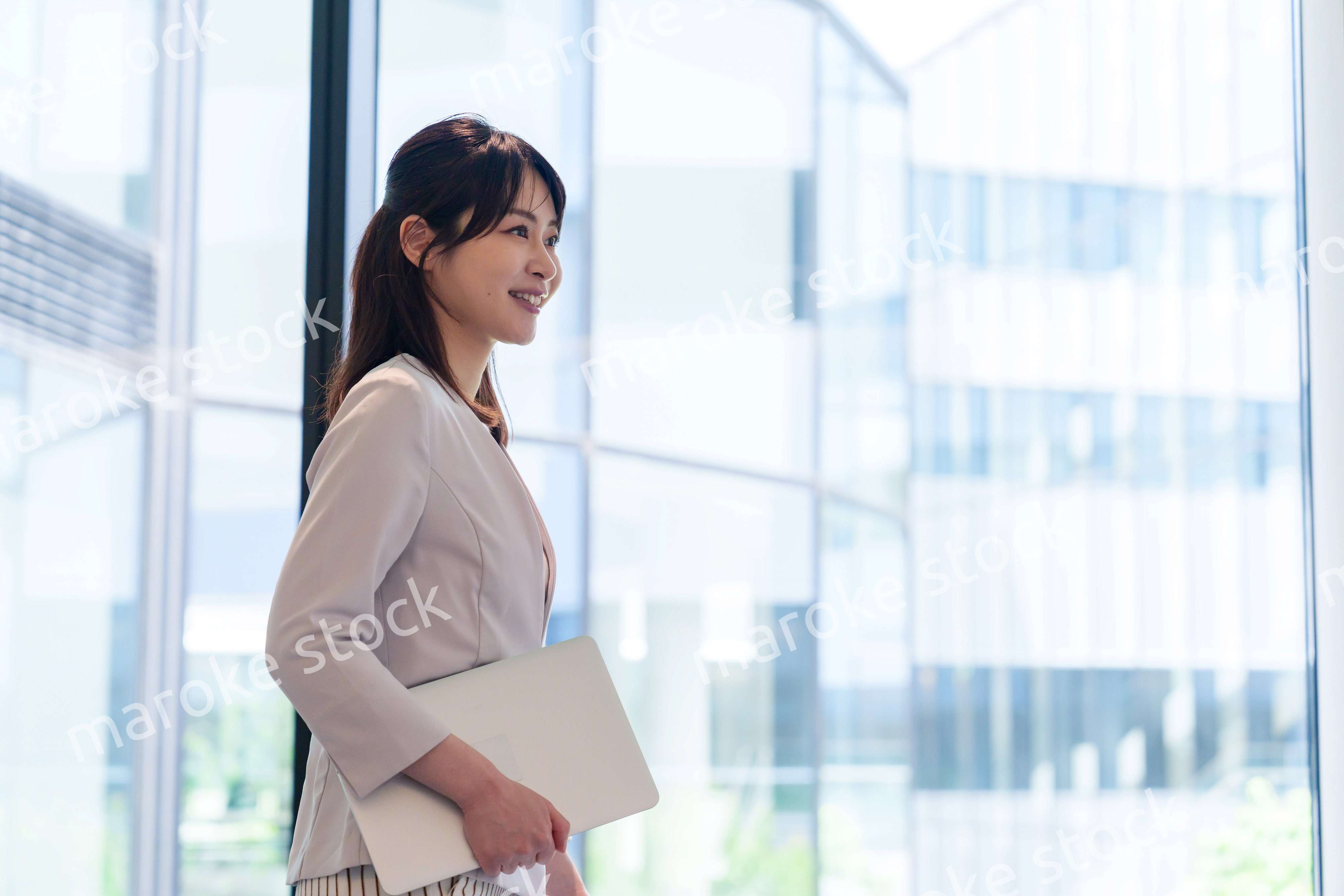 オフィスの中で笑顔で歩くビジネスウーマン