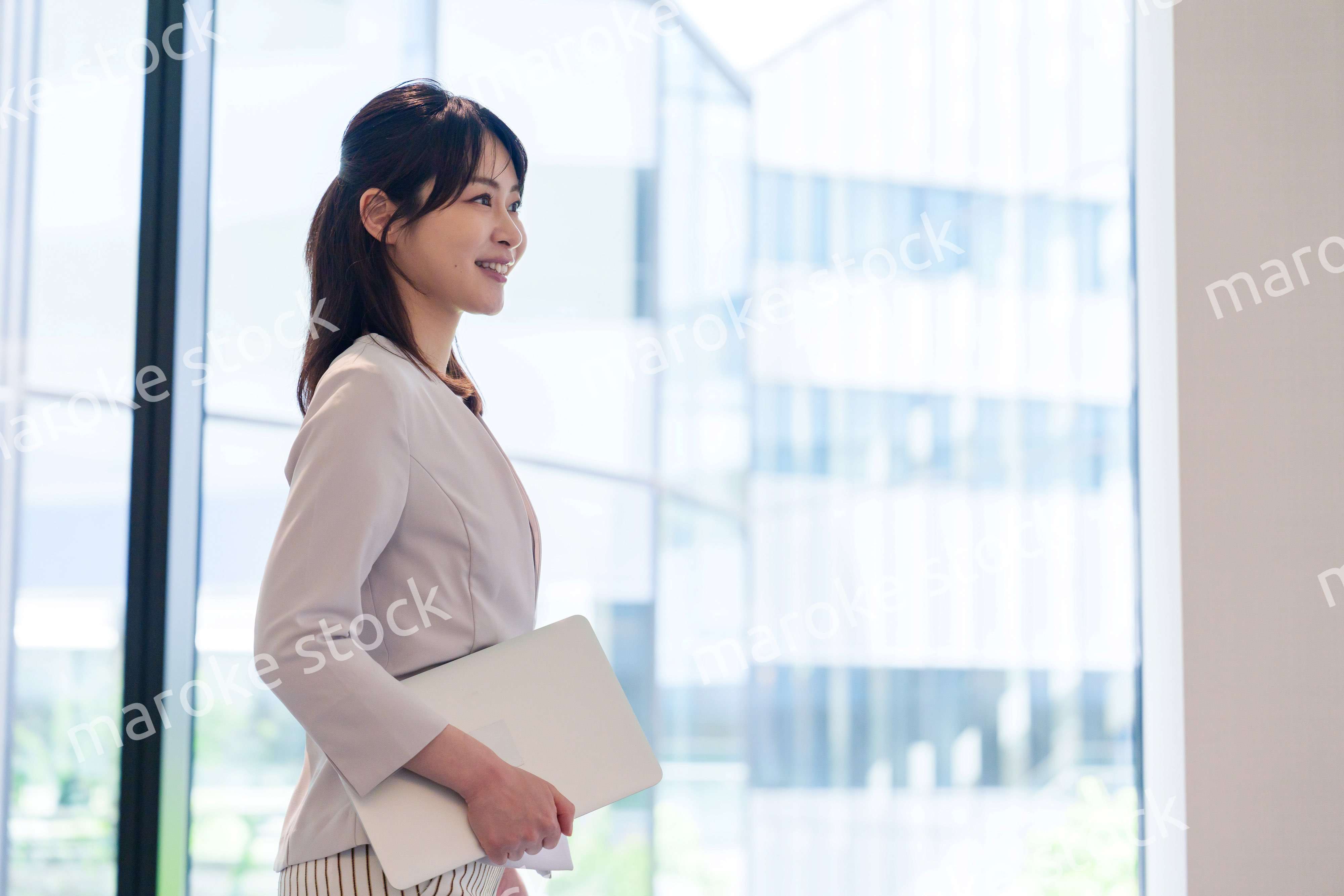 オフィスの中で笑顔で歩くビジネスウーマン