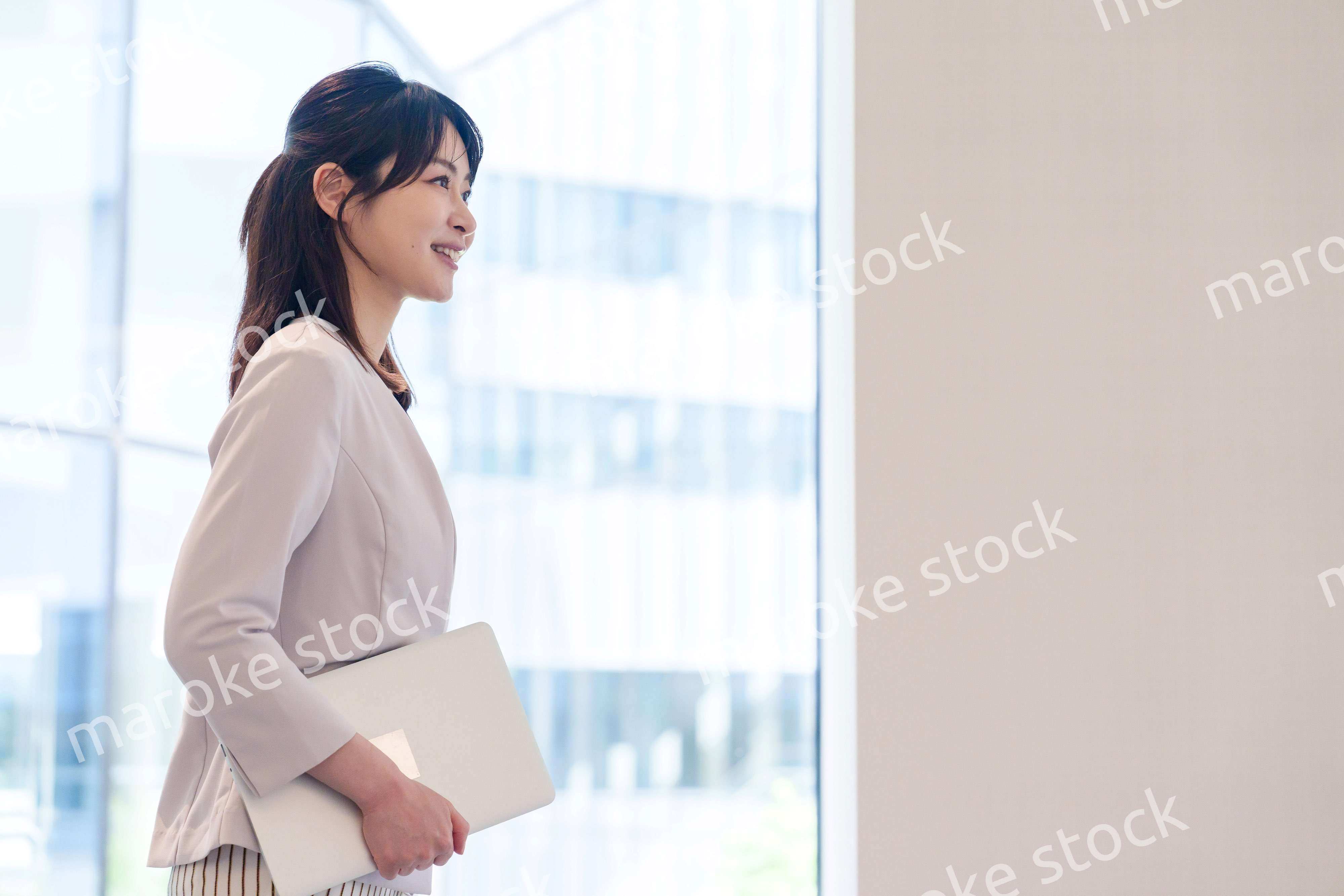 オフィスの中で笑顔で歩くビジネスウーマン