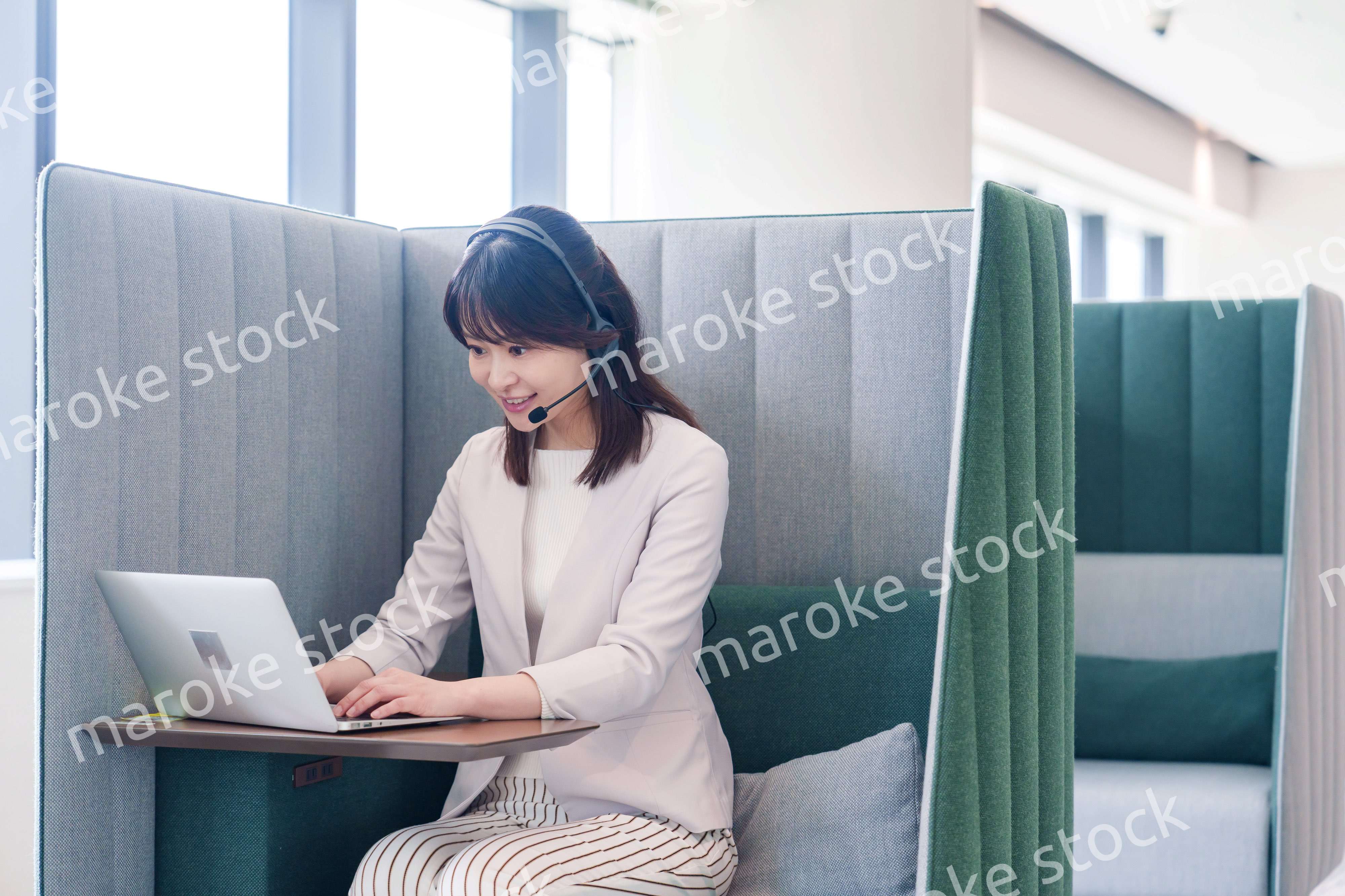 コワーキングスペースのブースで働く若い女性