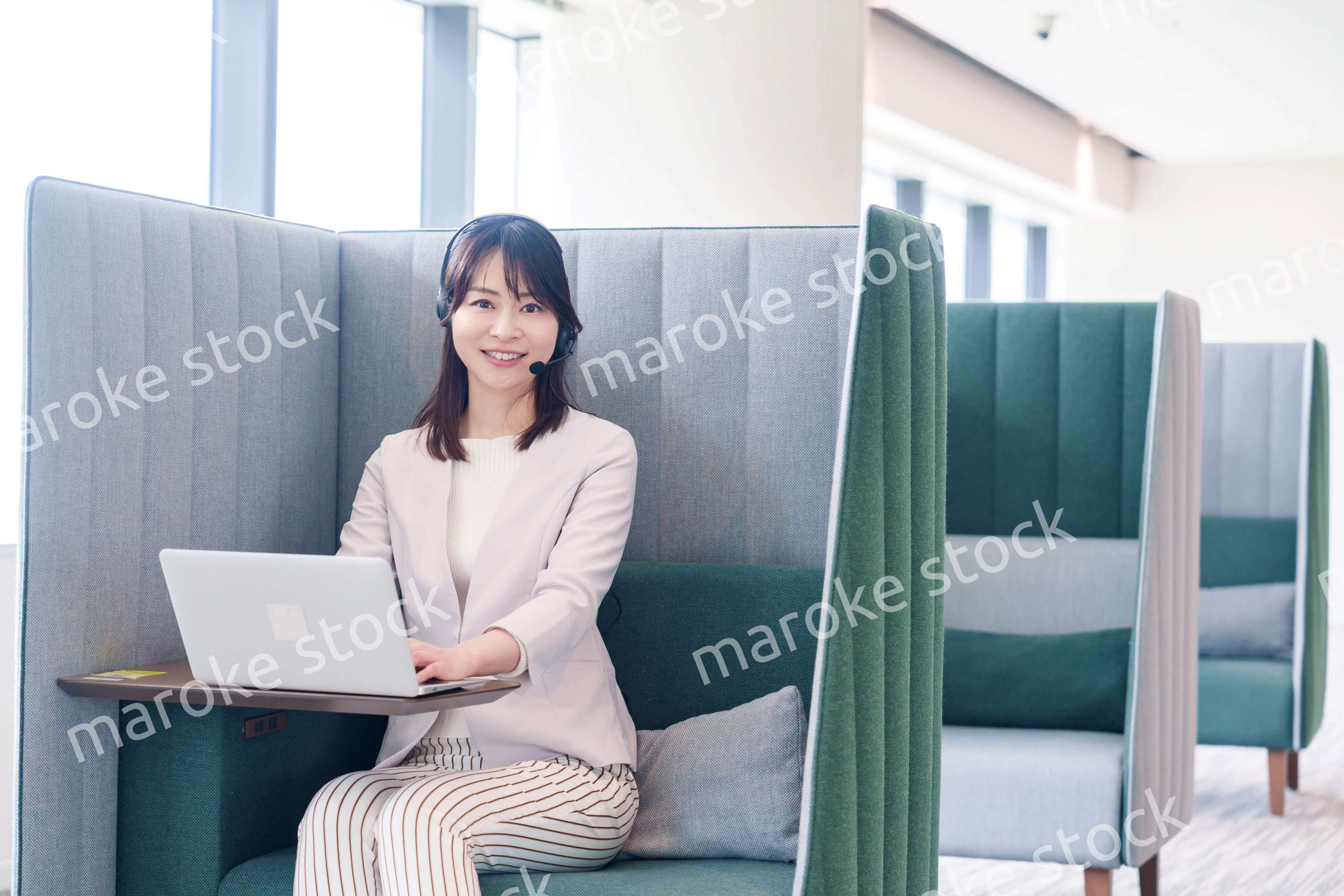 コワーキングスペースのブースで働く若い女性