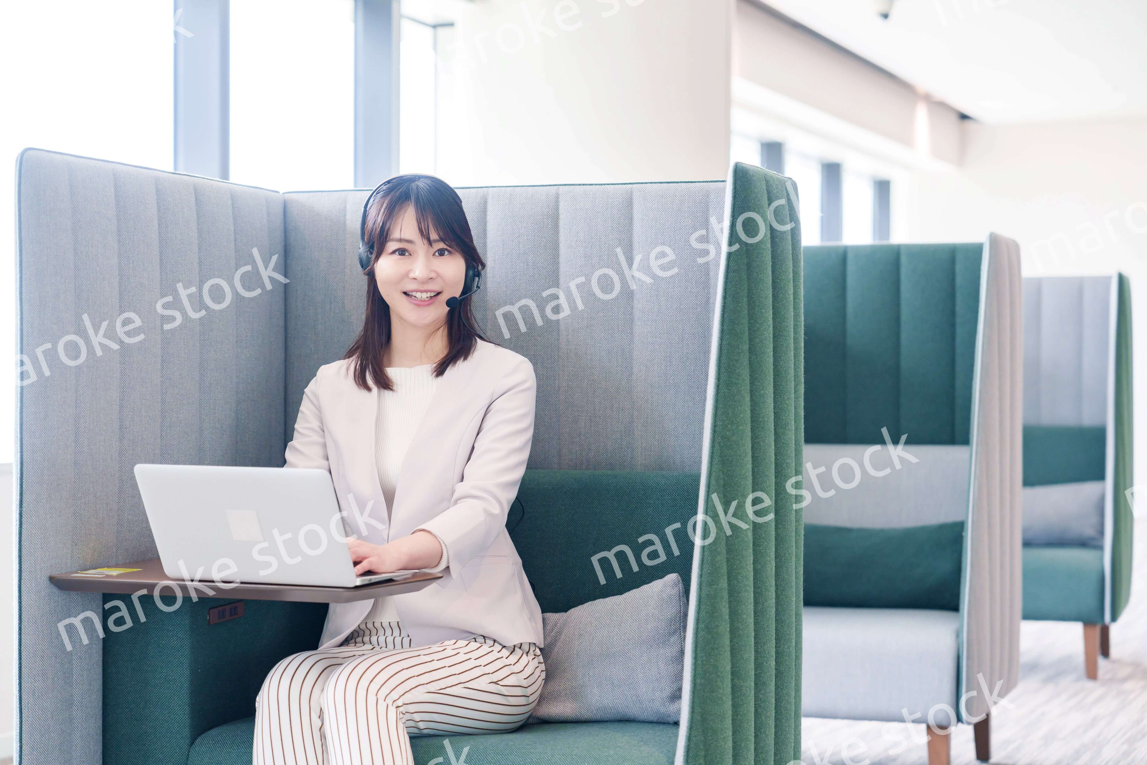 コワーキングスペースのブースで働く若い女性