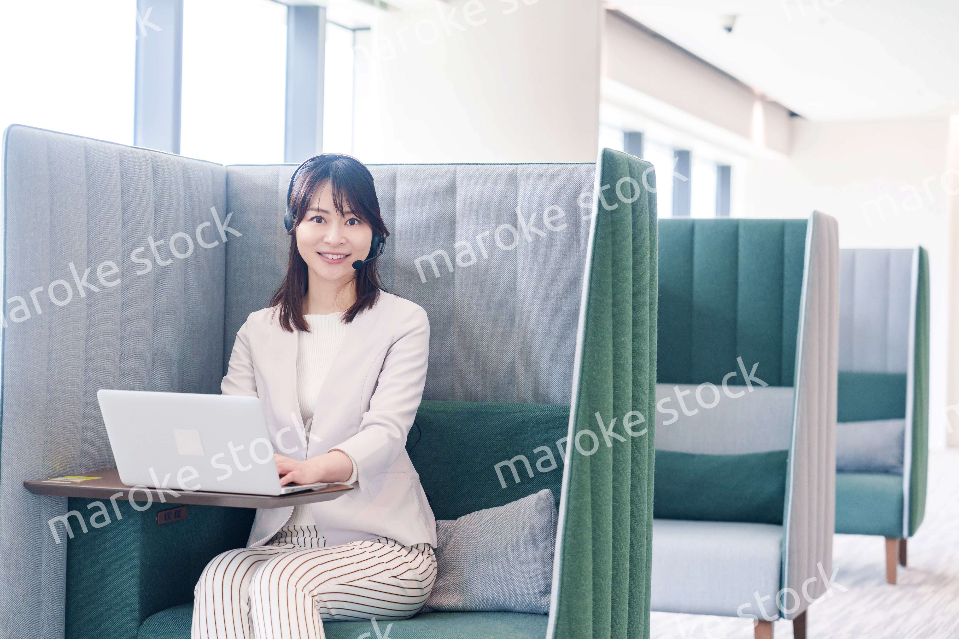 コワーキングスペースのブースで働く若い女性