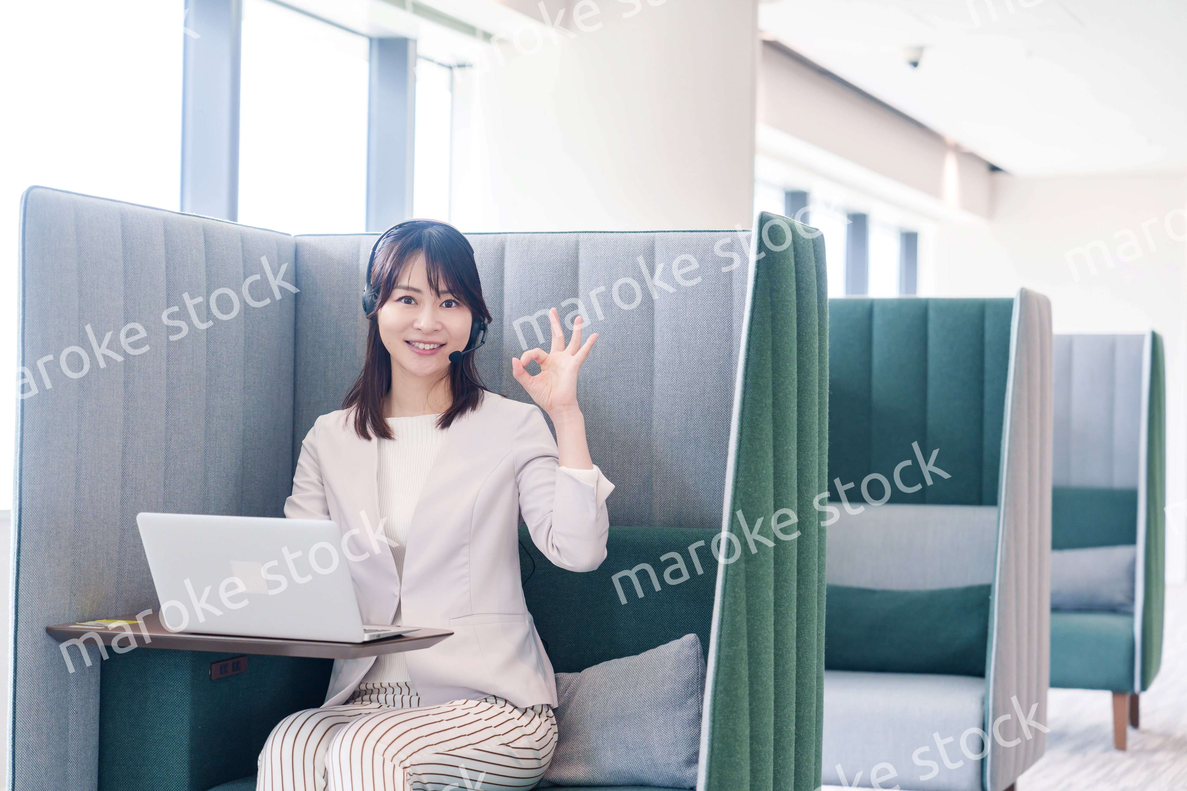 コワーキングスペースのブースで働く若い女性