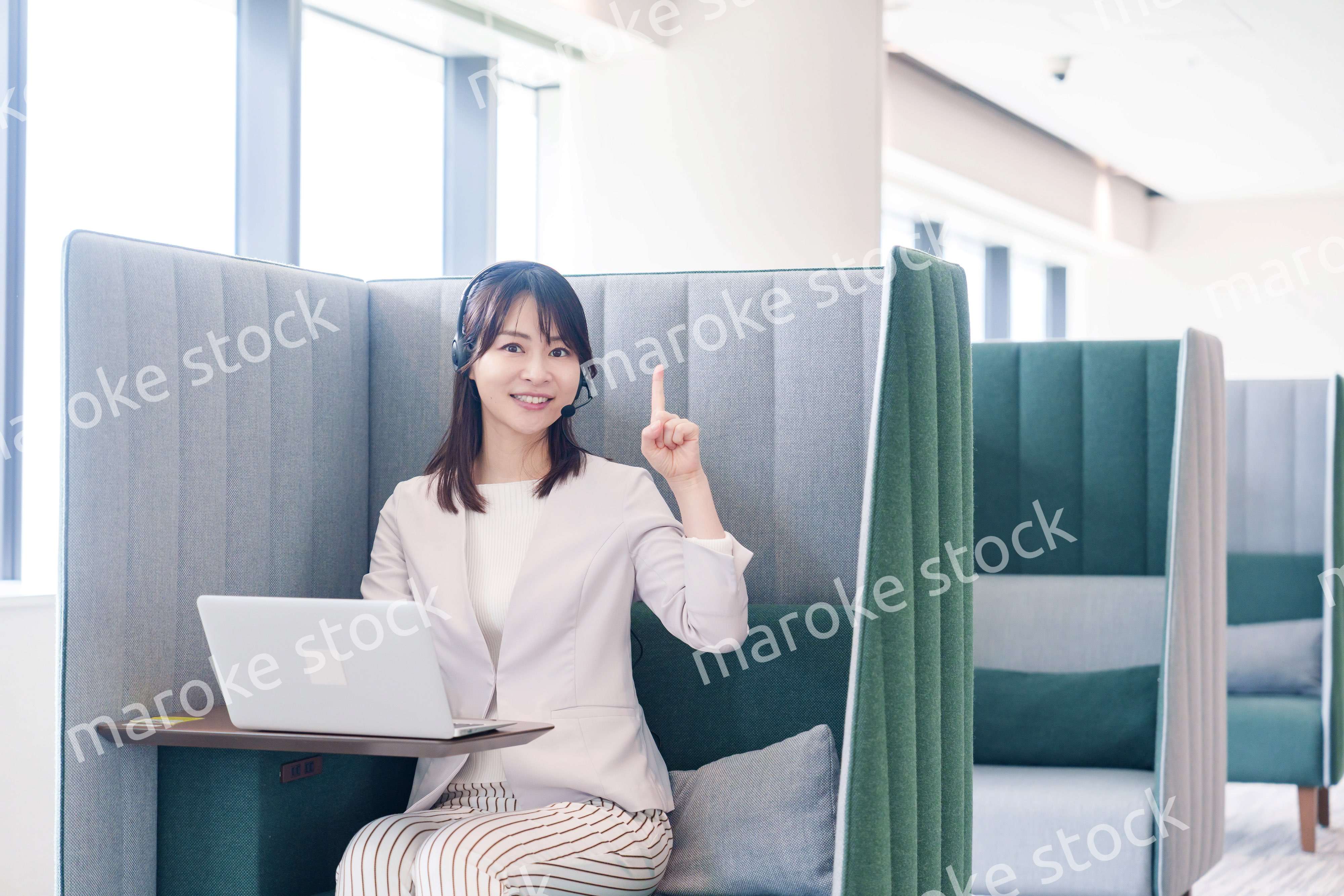 コワーキングスペースのブースで働く若い女性