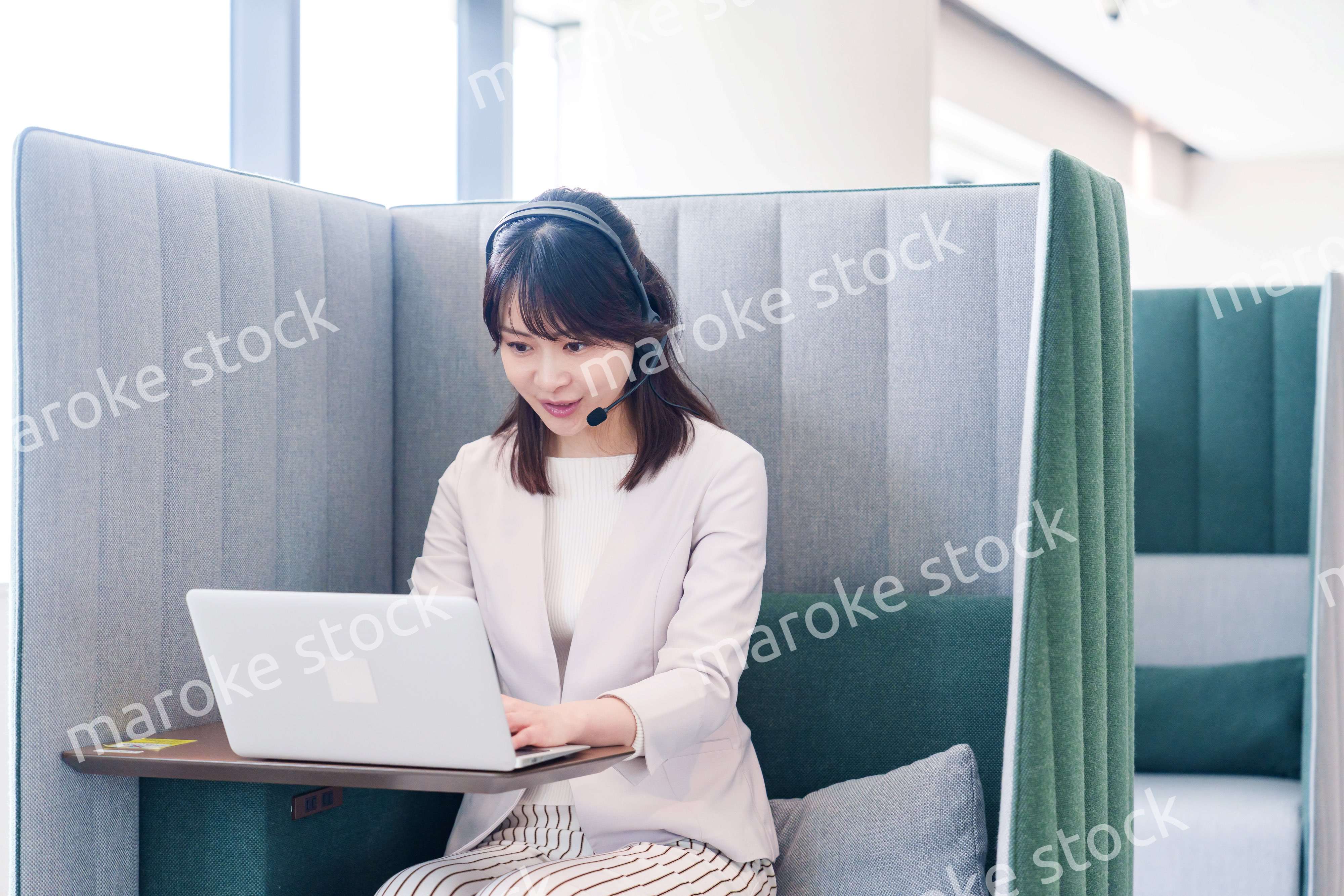 コワーキングスペースでリモート会議に参加する若い女性