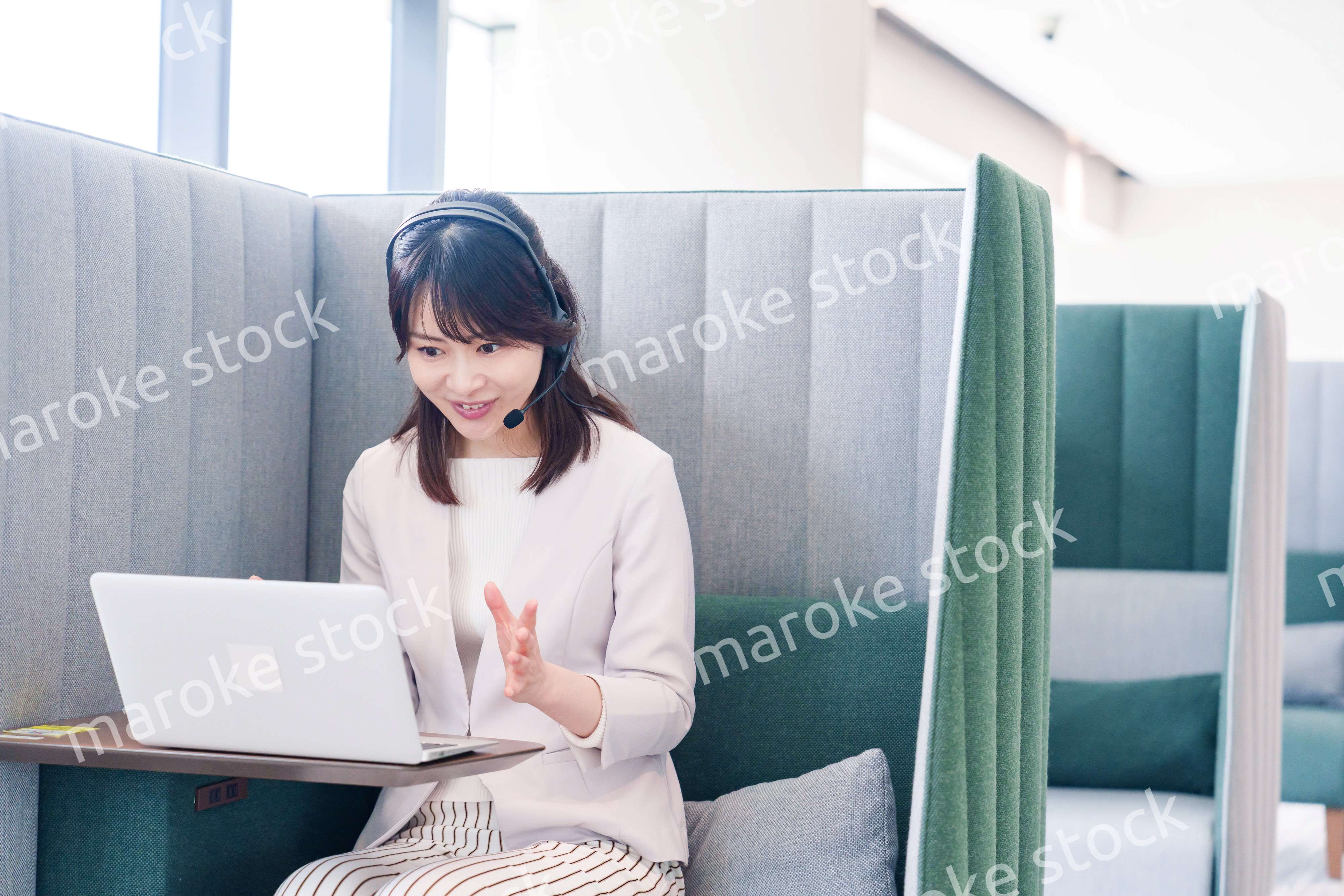 コワーキングスペースでリモート会議に参加する若い女性