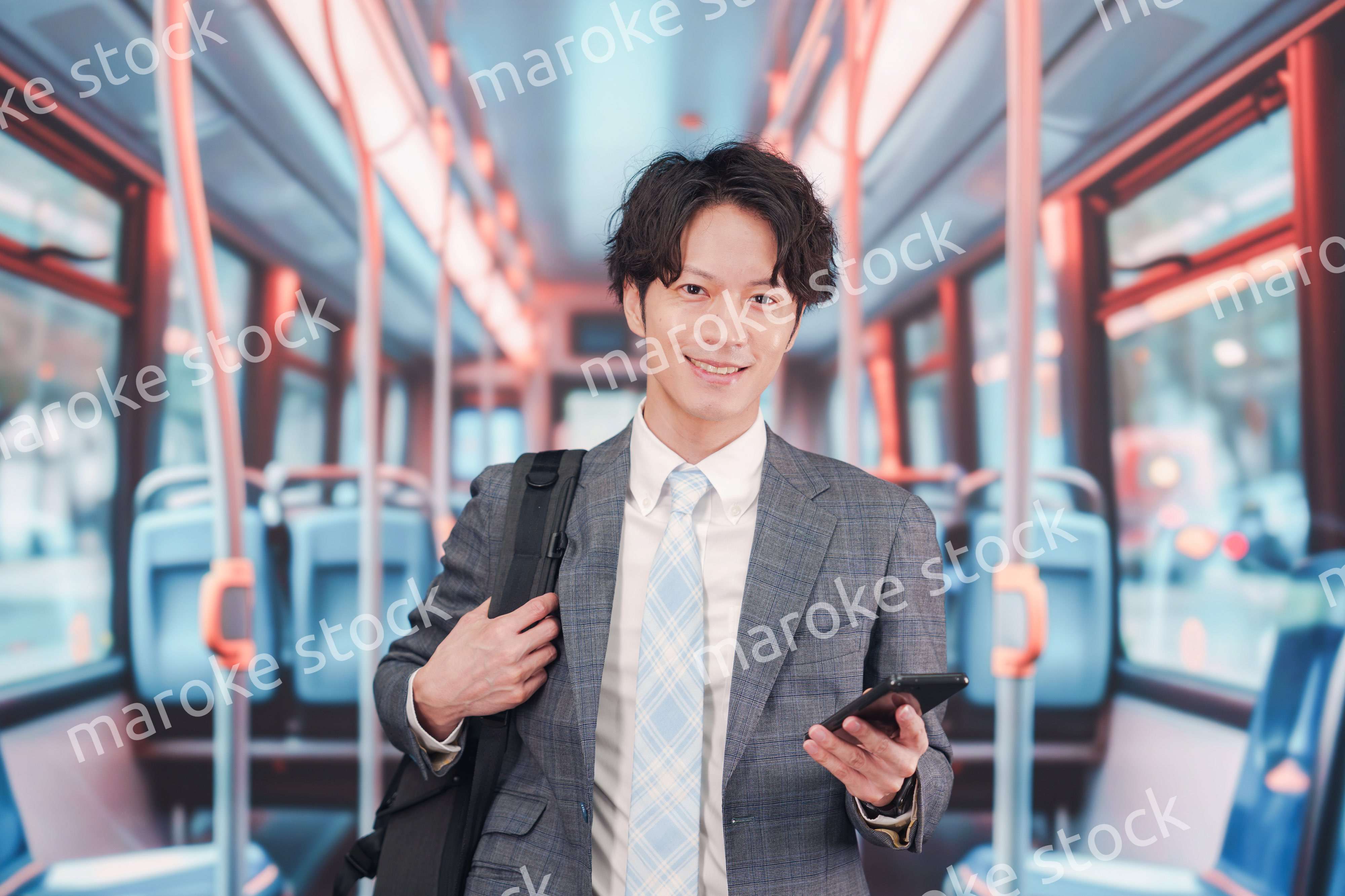 バスで通勤をするスーツを着たビジネスマン