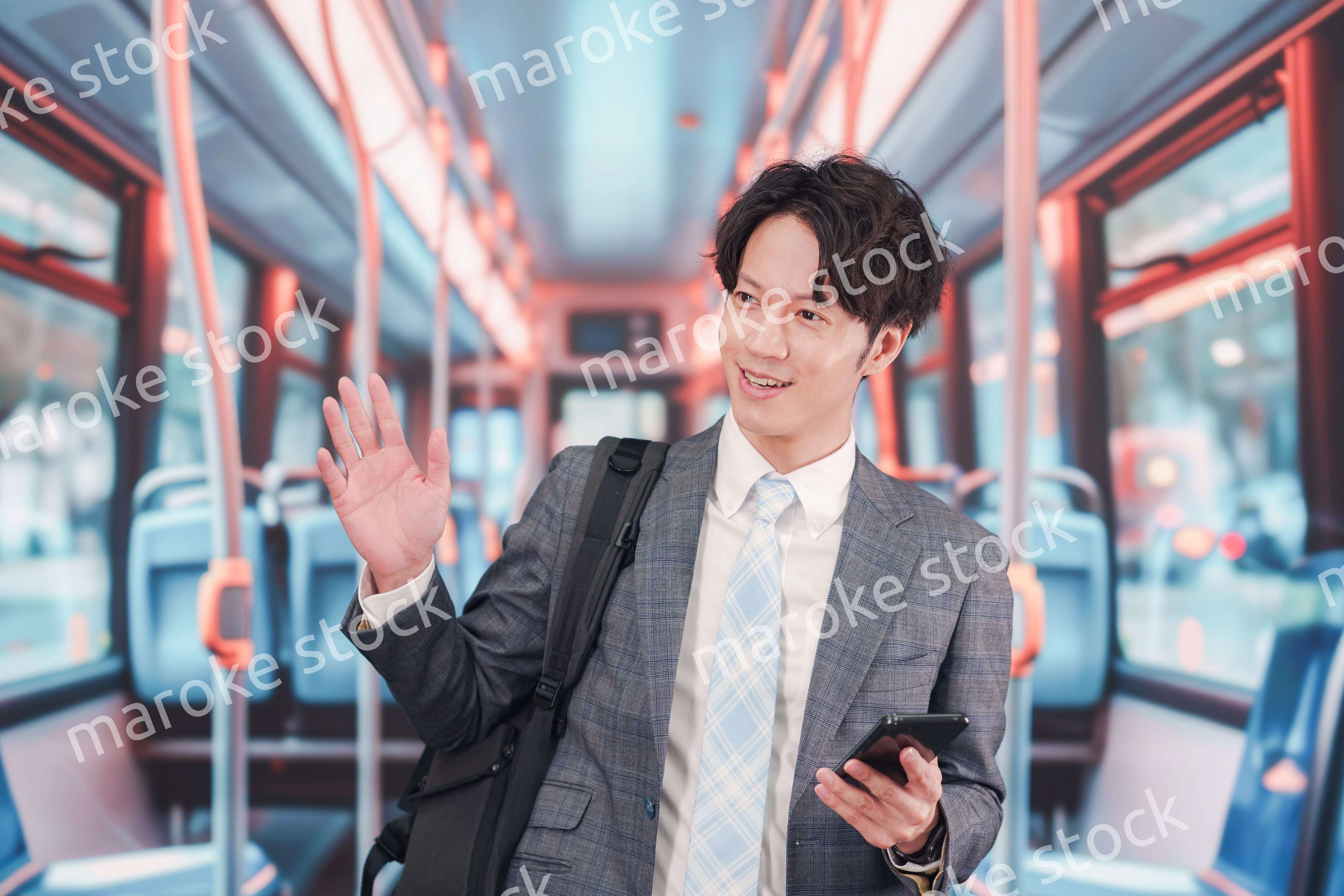 バスで通勤をするスーツを着たビジネスマン