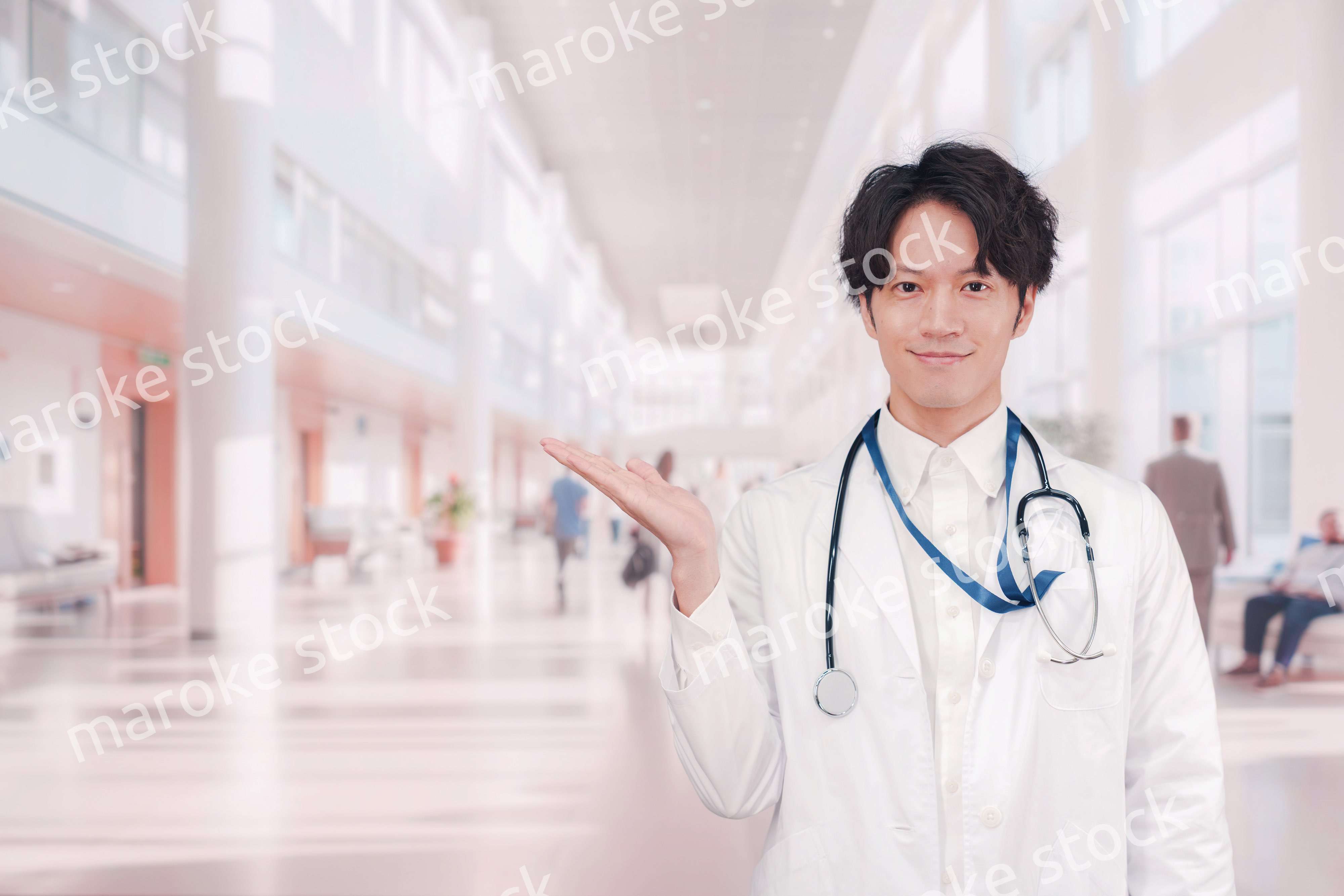 明るい病院で働く白衣を着た若い男性ドクター