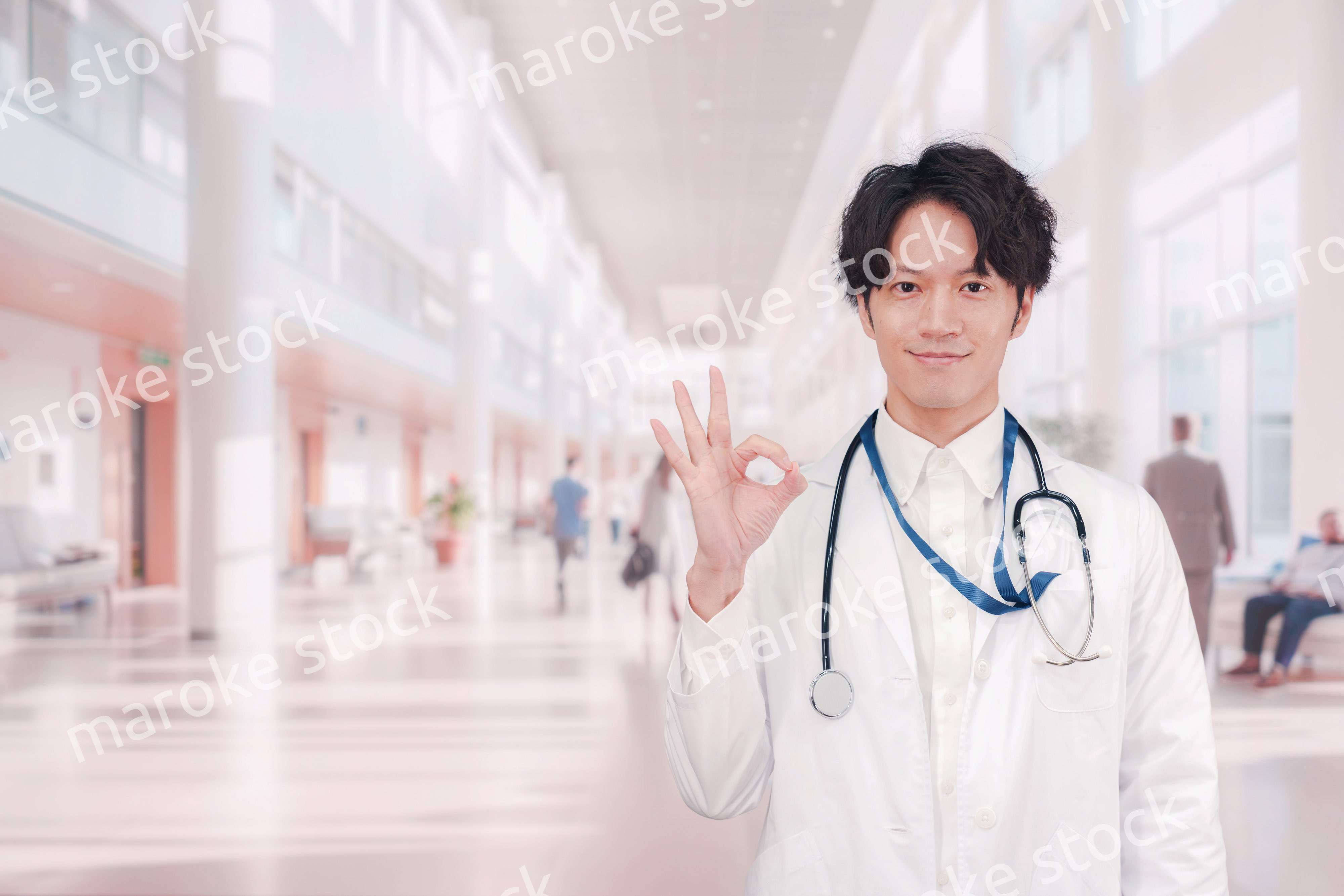 明るい病院で働く白衣を着た若い男性ドクター