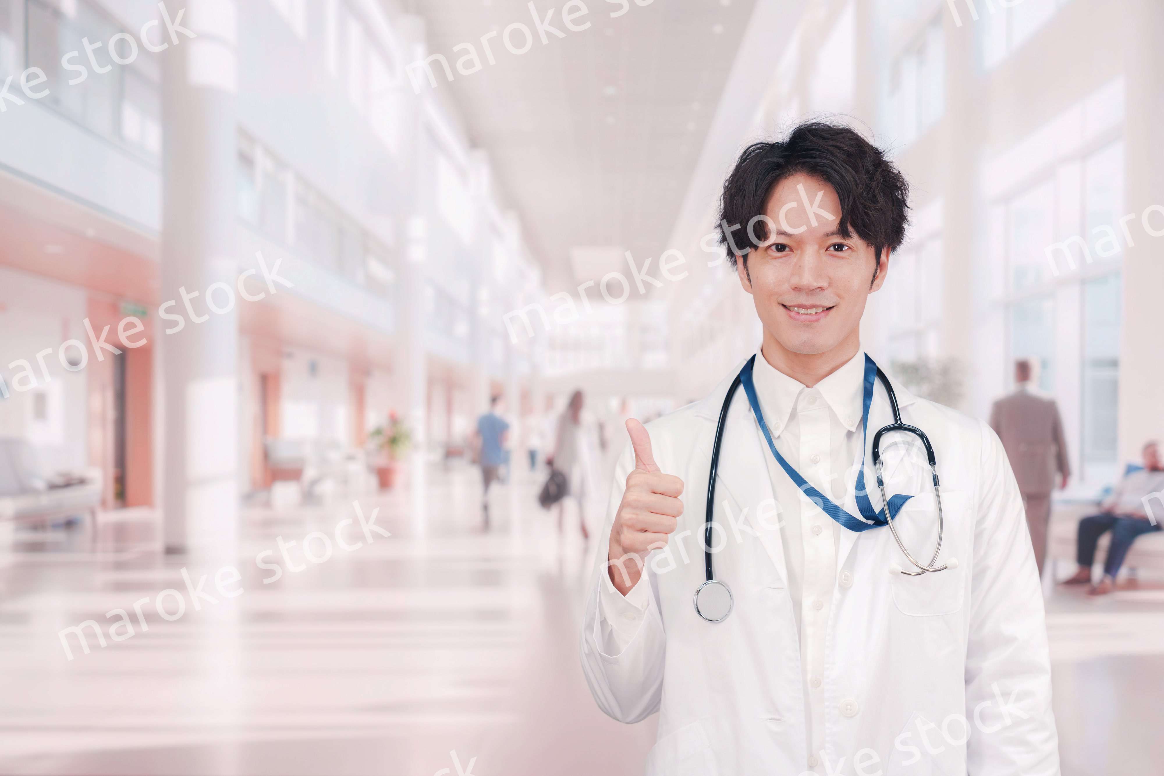 明るい病院で働く白衣を着た若い男性ドクター