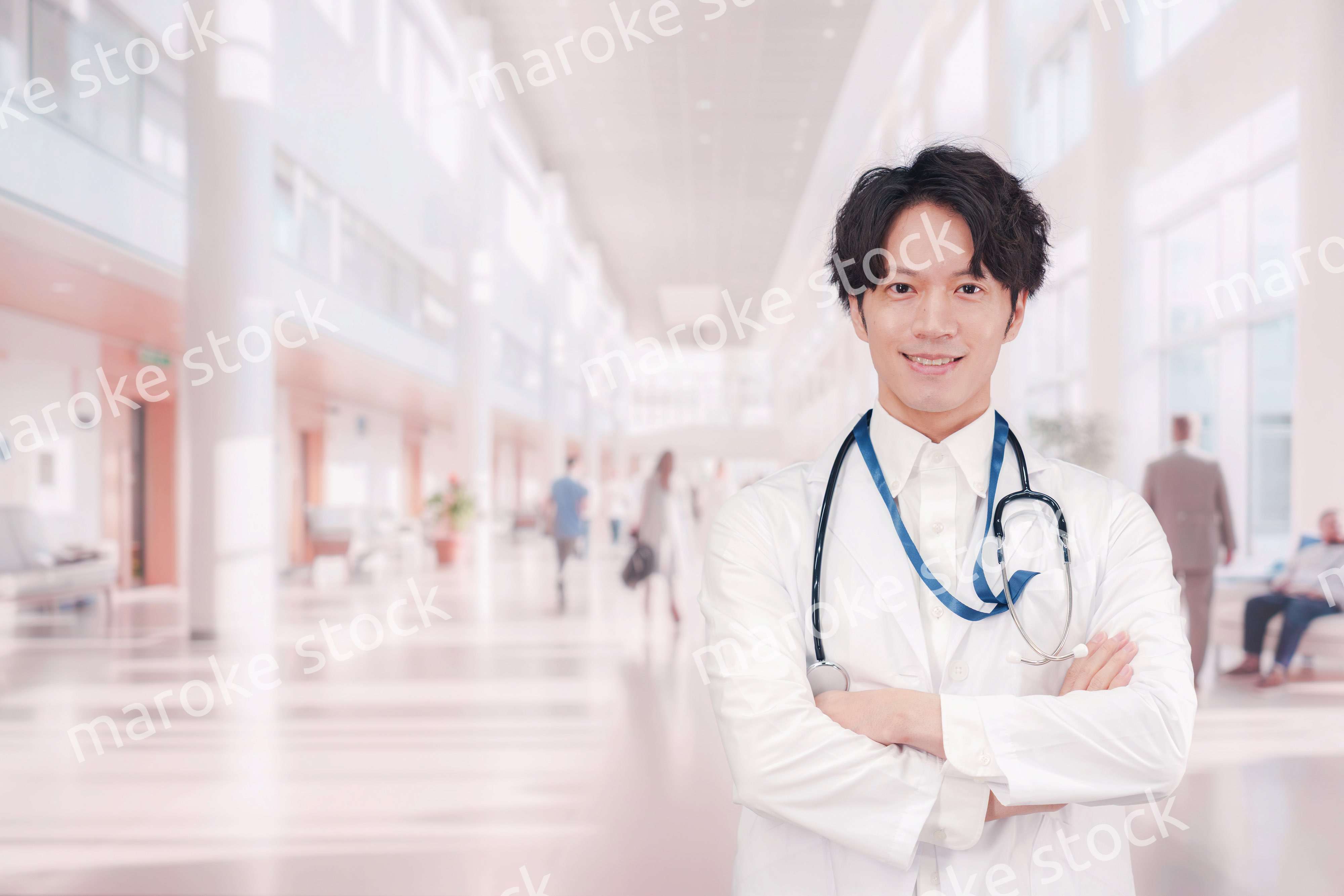 明るい病院で働く白衣を着た若い男性ドクター