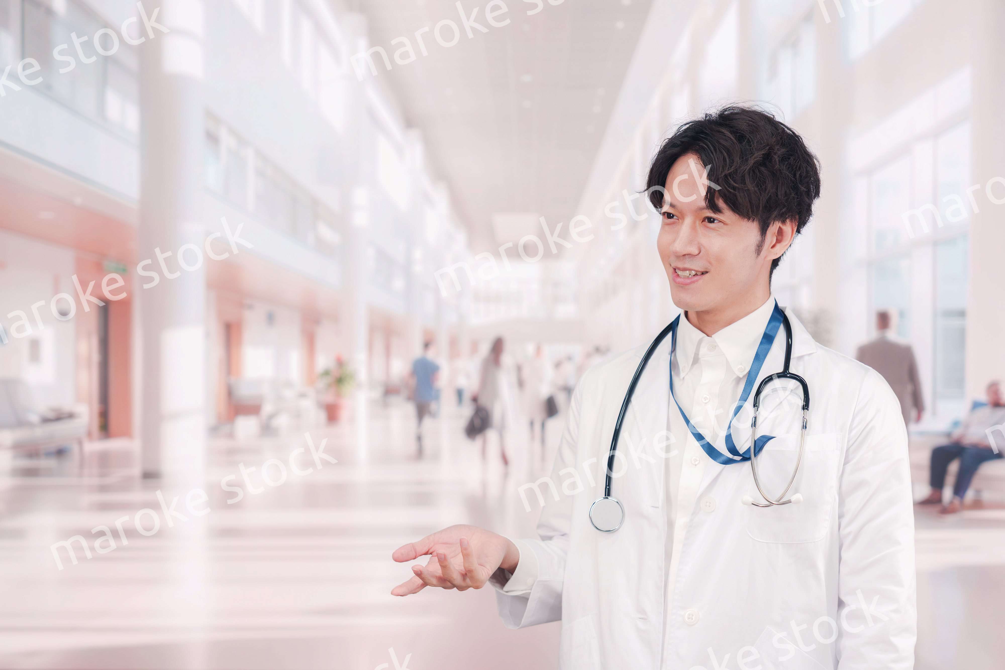 明るい病院で働く白衣を着た若い男性ドクター