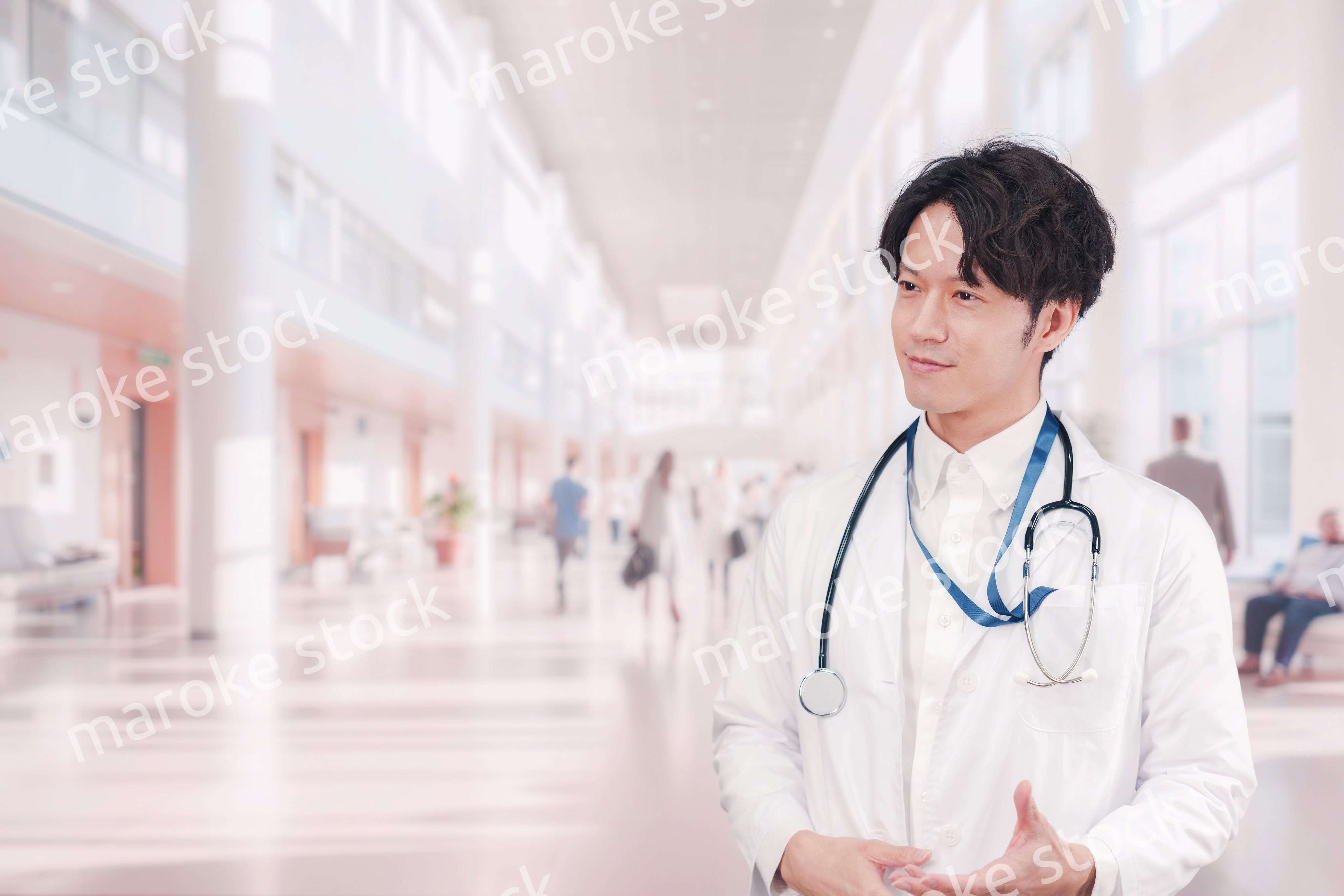 明るい病院で働く白衣を着た若い男性ドクター