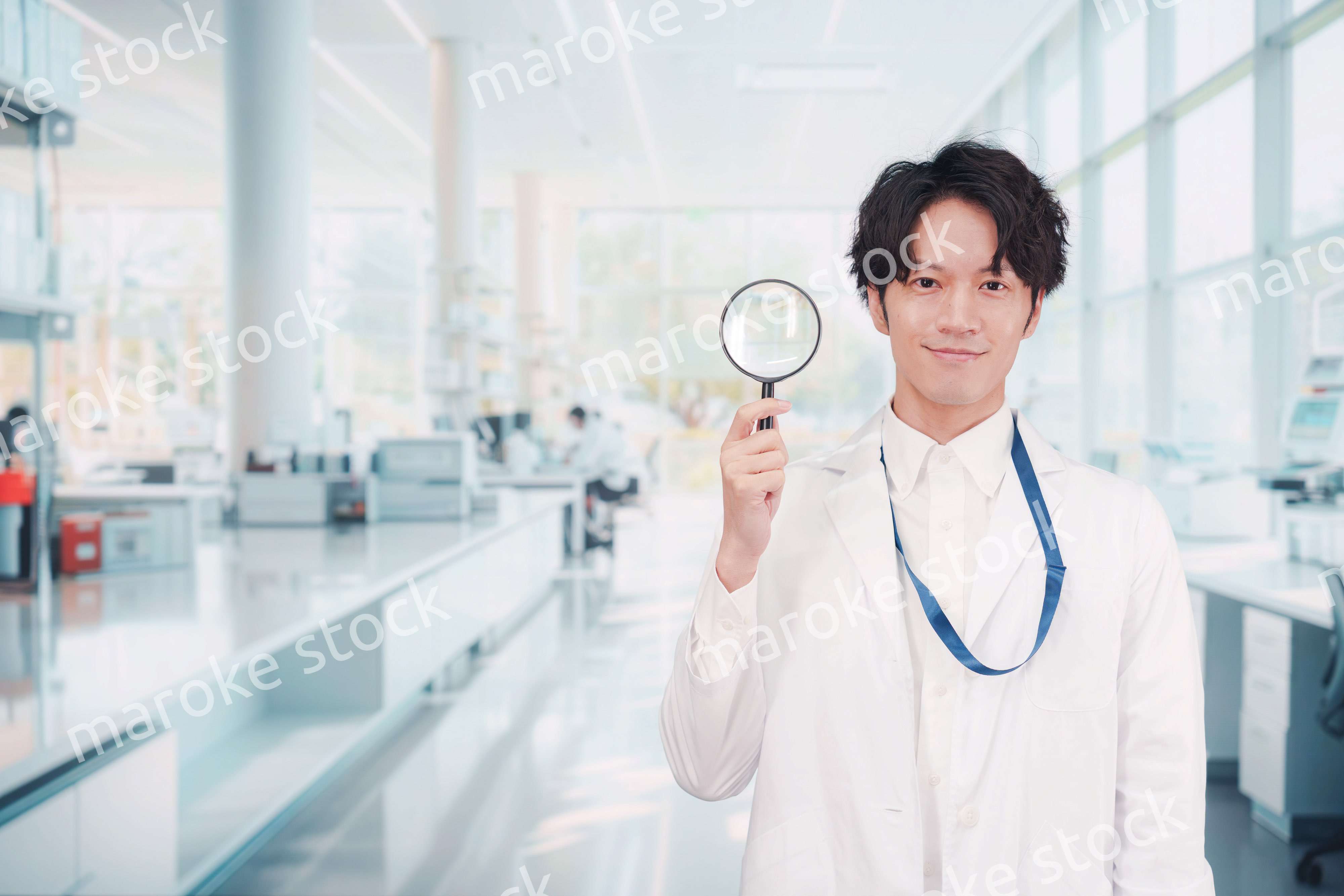 虫眼鏡を持つ白衣を着た男性