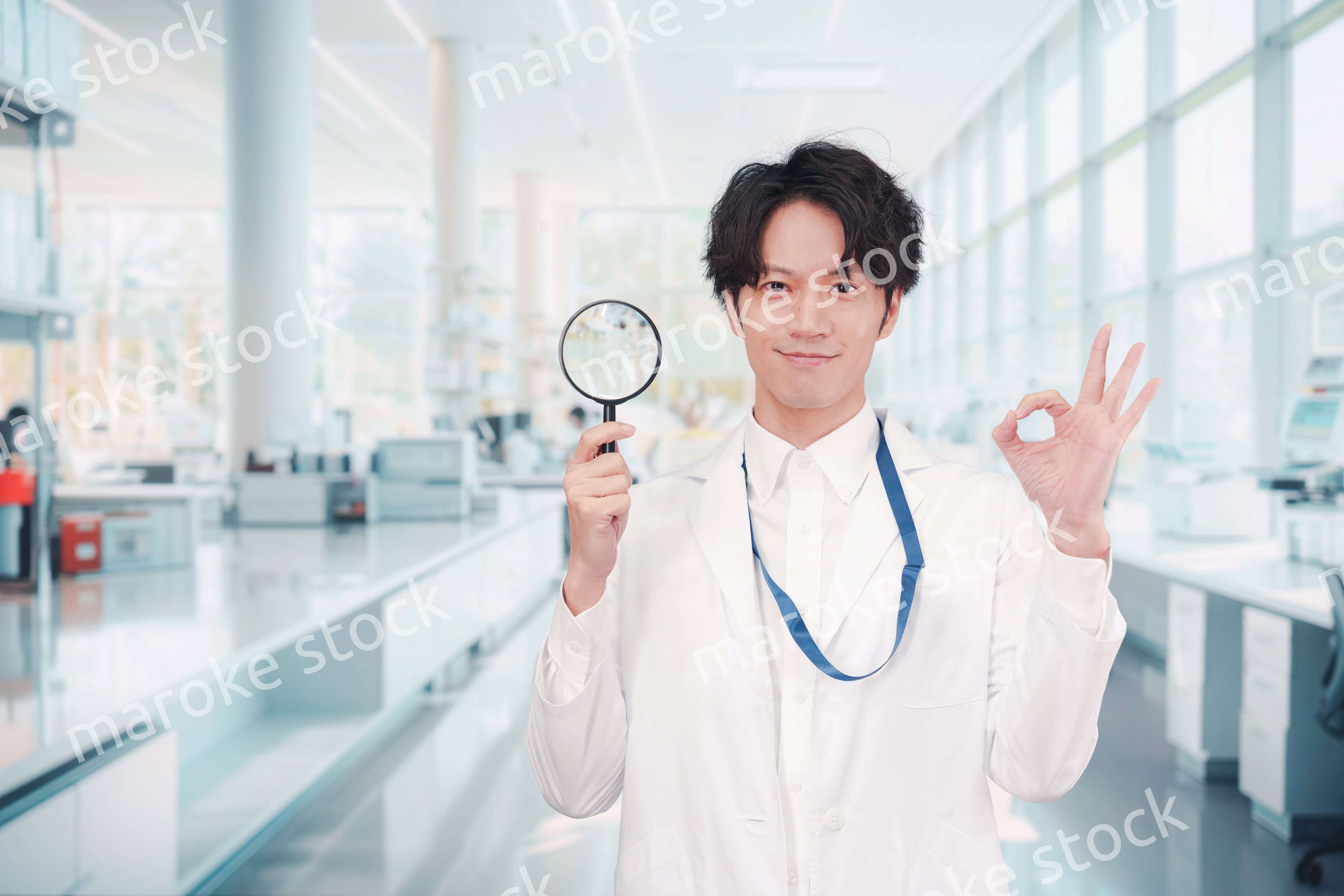 虫眼鏡を持つ白衣を着た男性