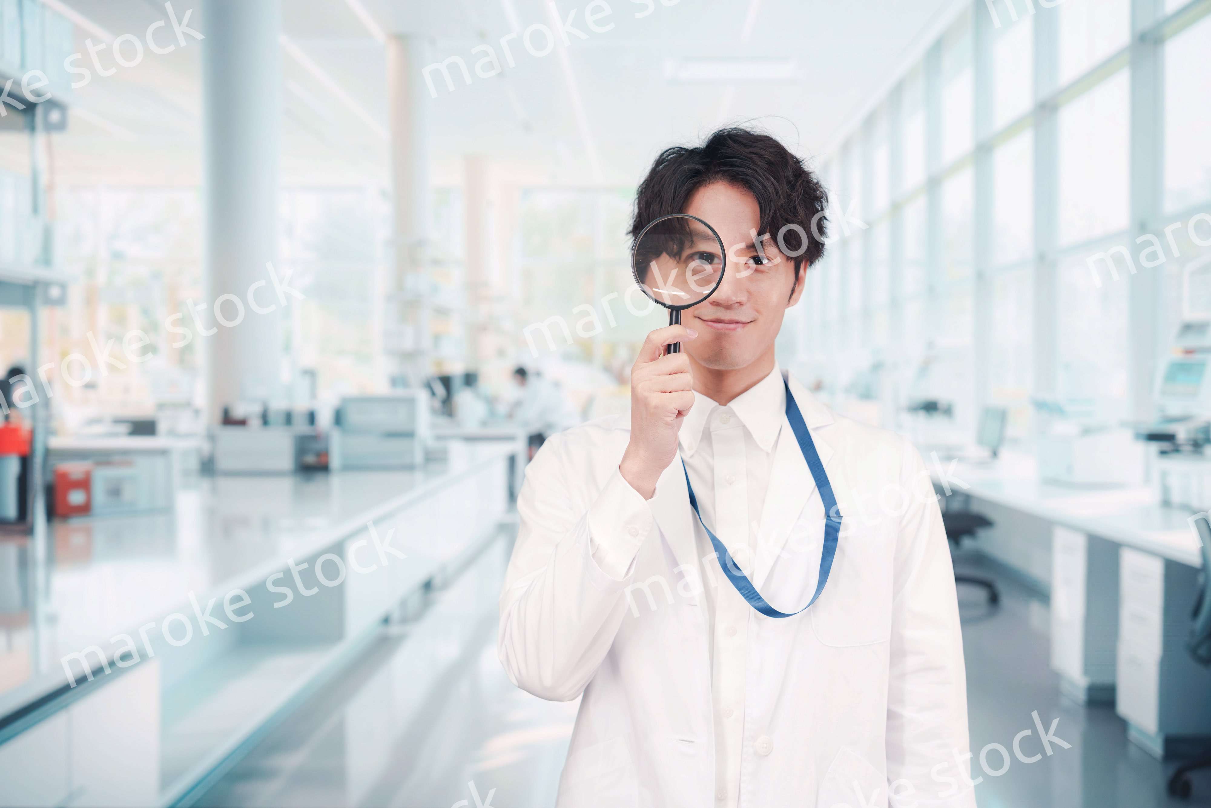 虫眼鏡を持つ白衣を着た男性