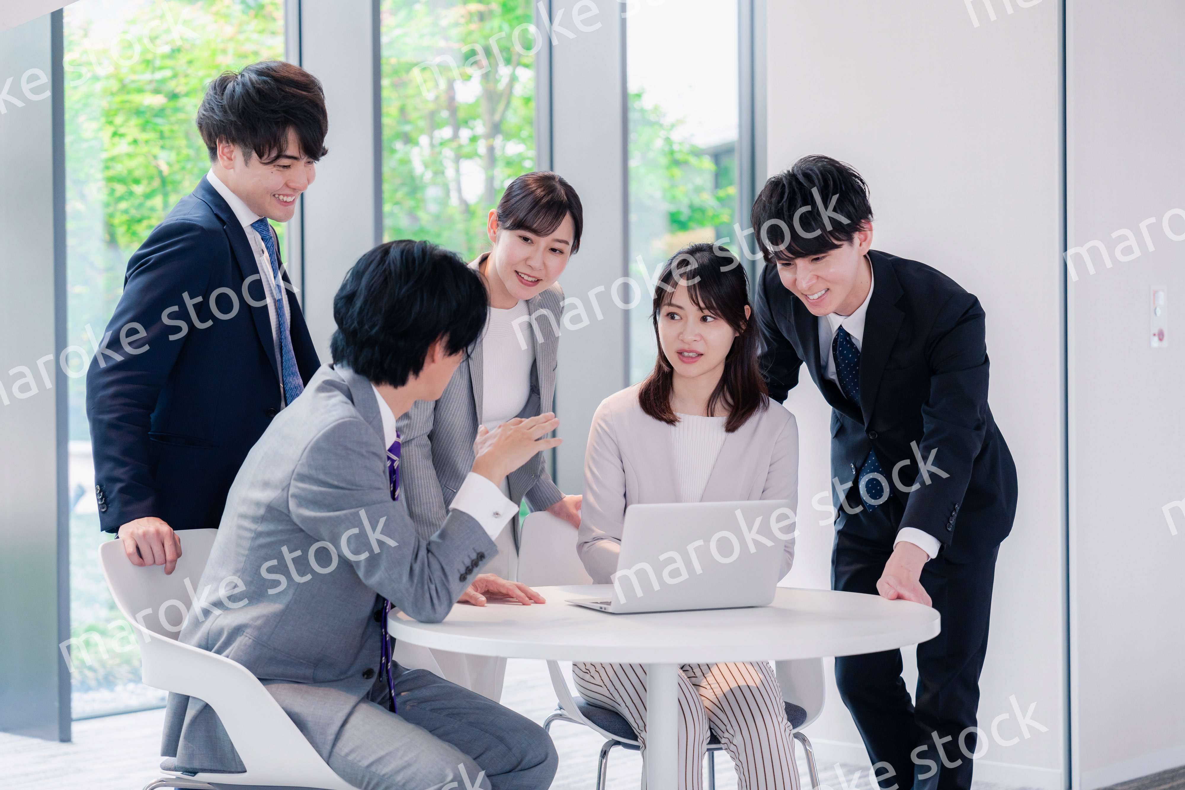 オフィスで笑顔で打ち合わせをするビジネスパーソン