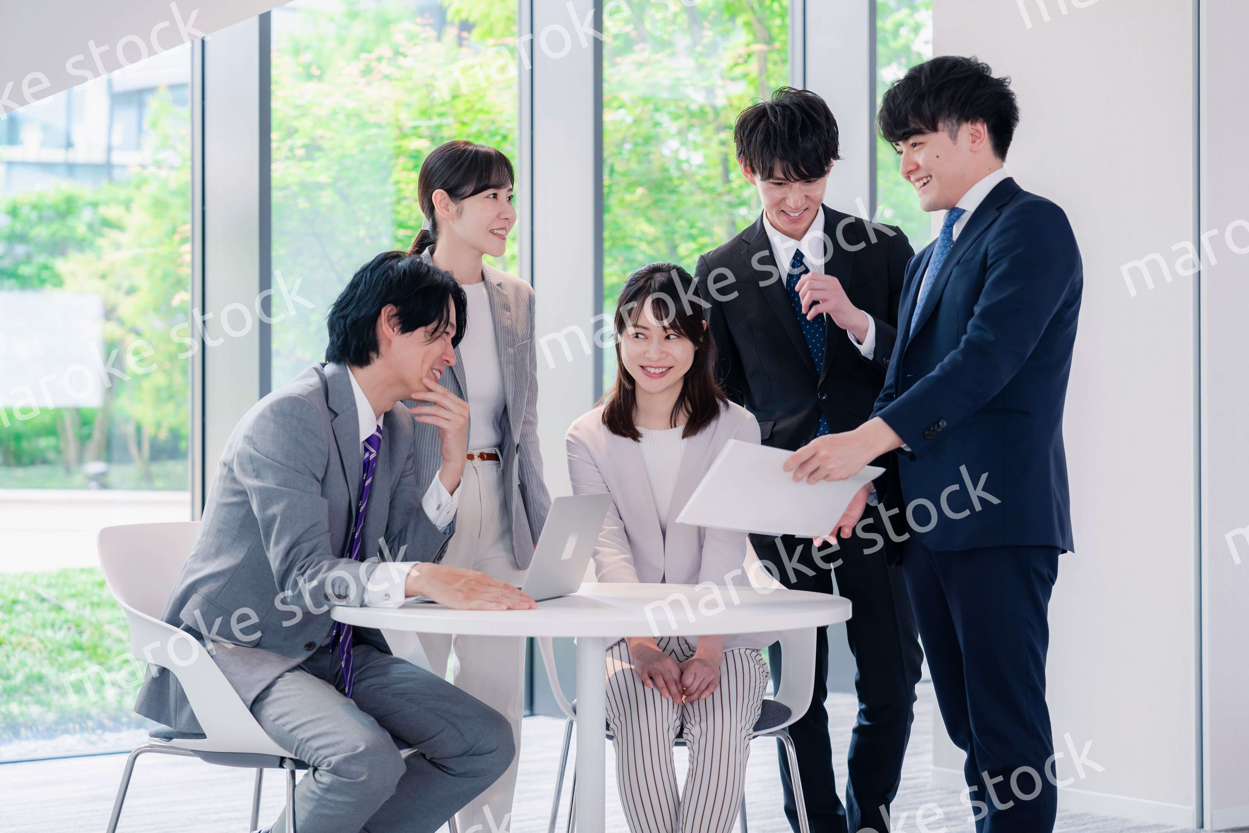 オフィスで笑顔で打ち合わせをするビジネスパーソン