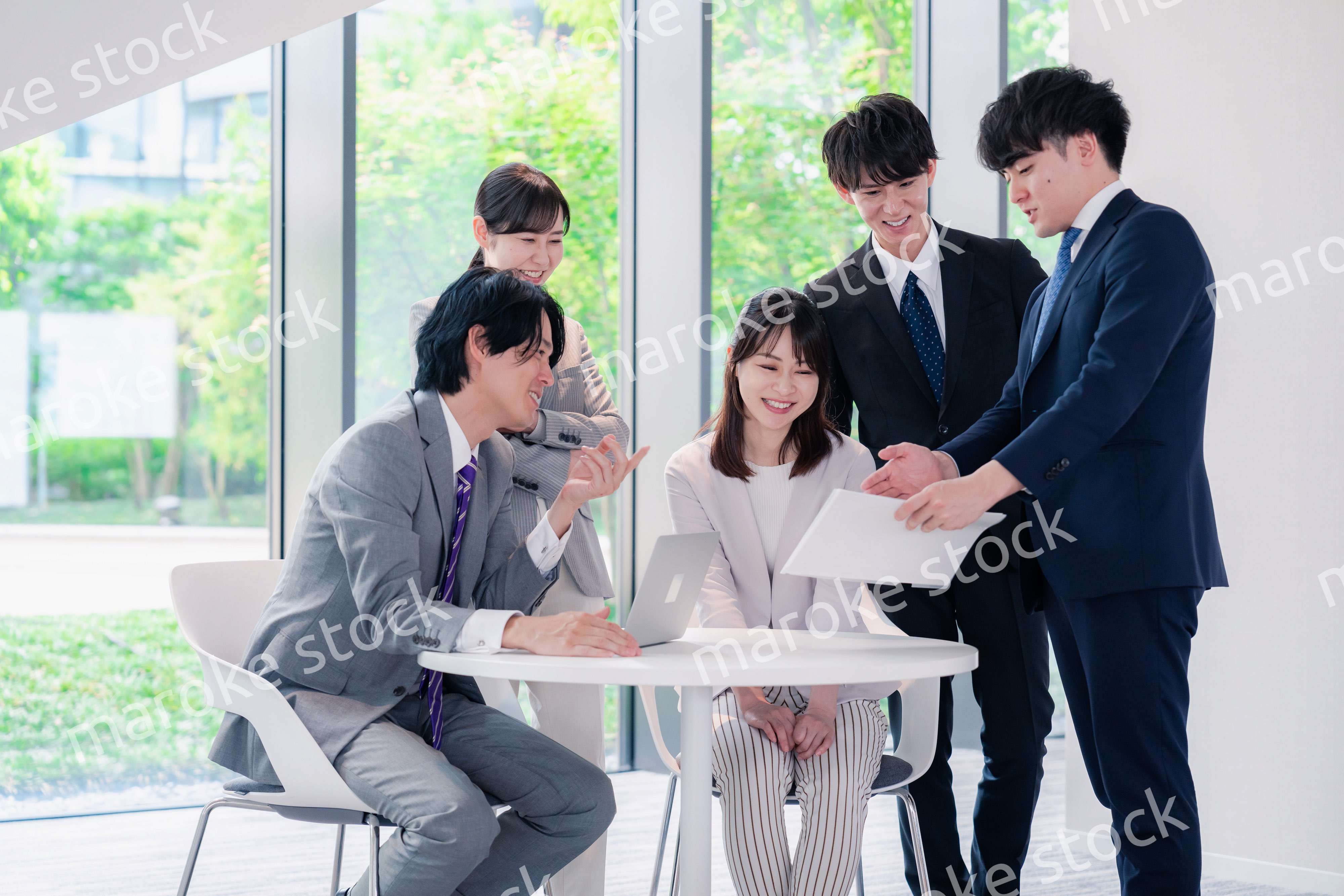 オフィスで笑顔で打ち合わせをするビジネスパーソン