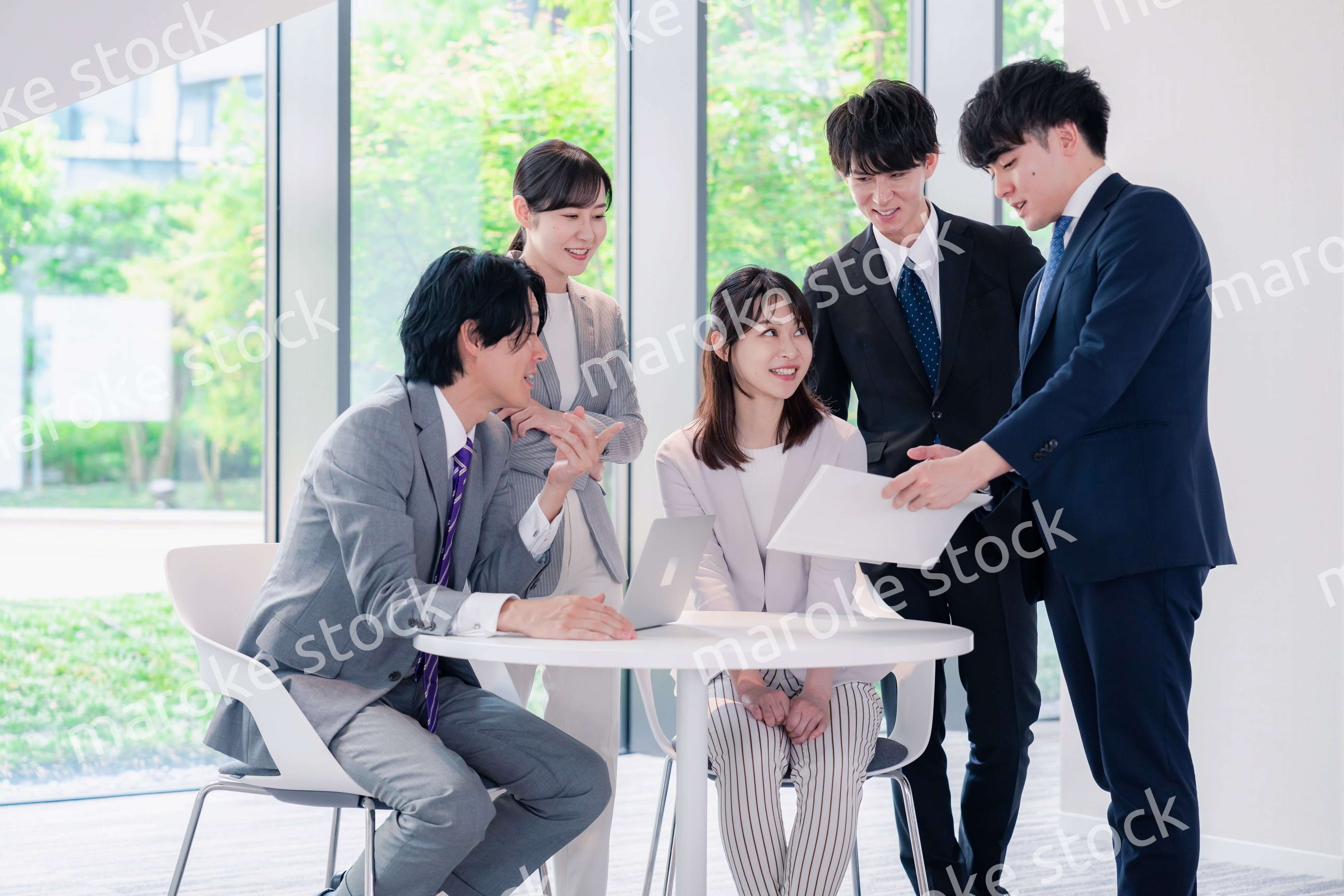 オフィスで笑顔で打ち合わせをするビジネスパーソン