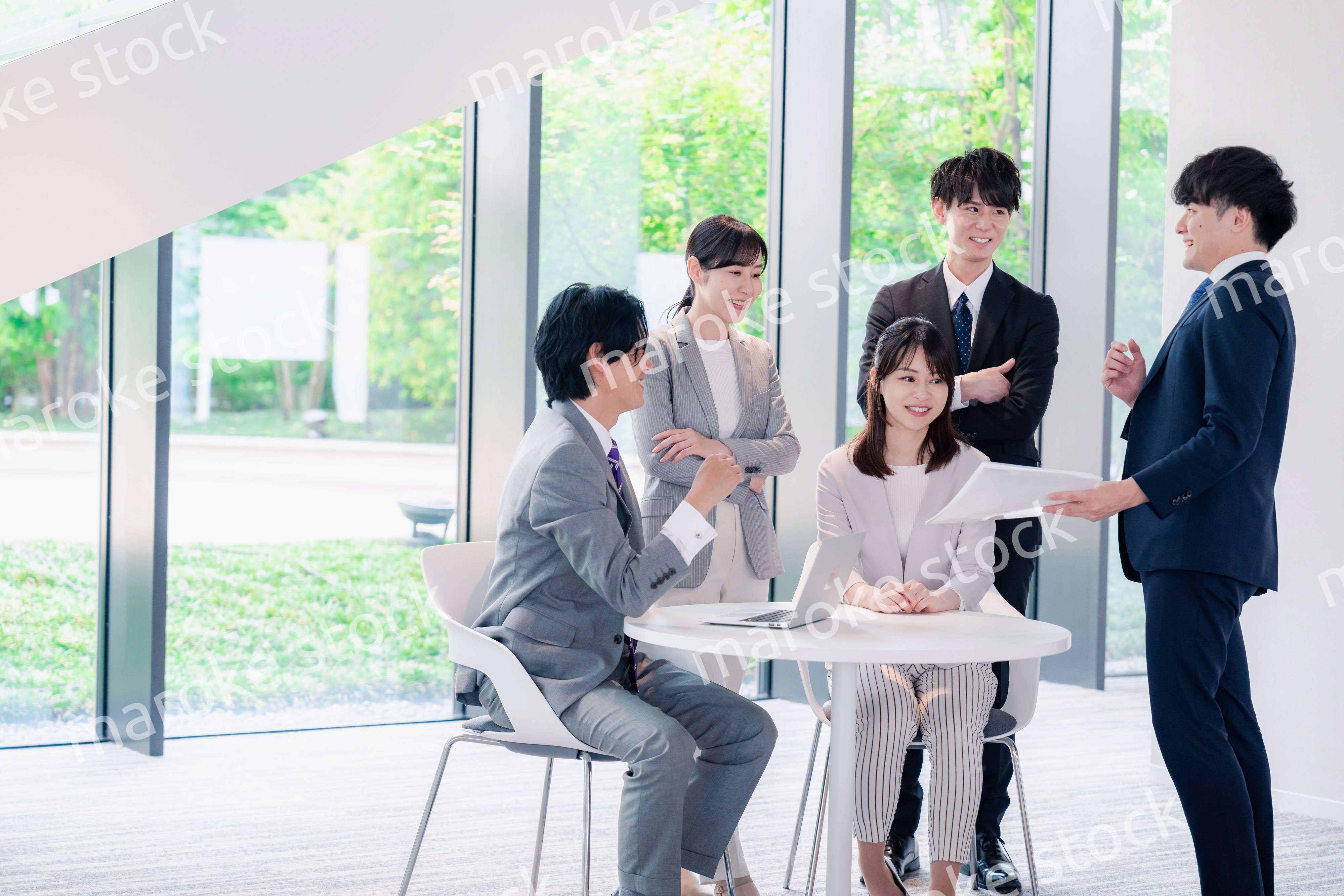 オフィスで笑顔で打ち合わせをするビジネスパーソン