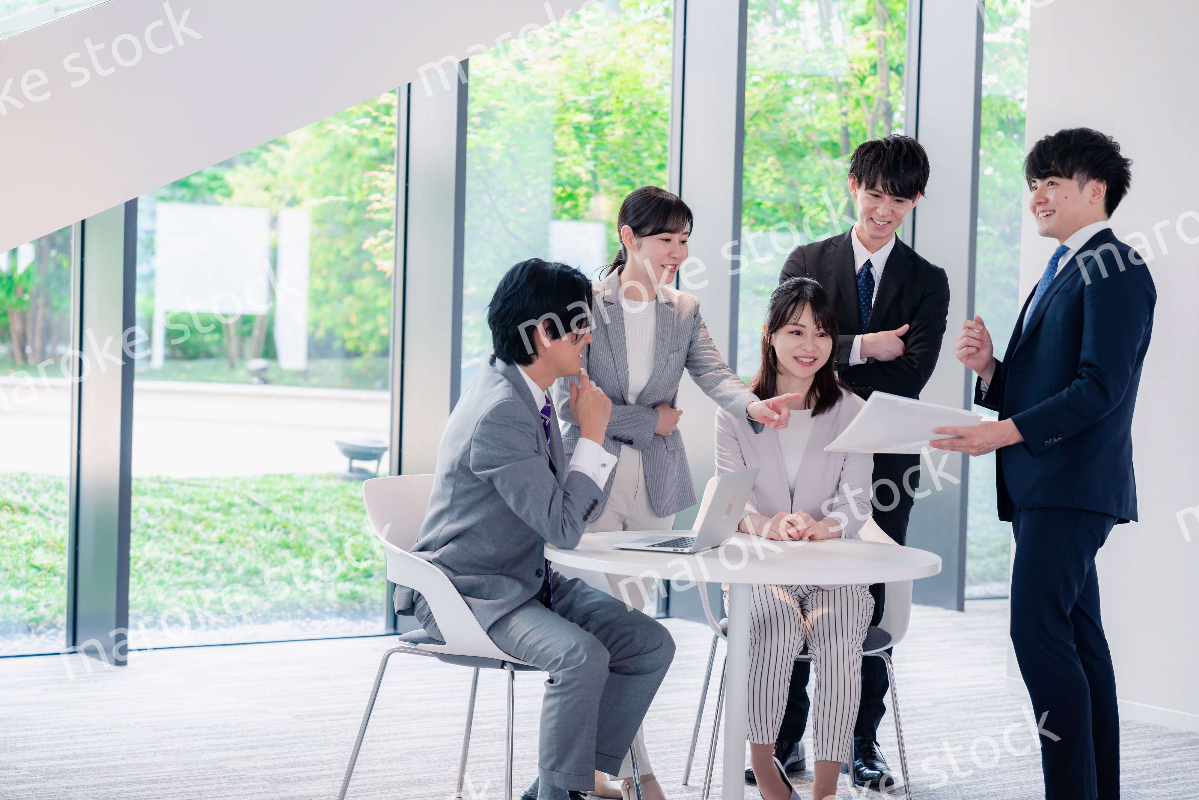 オフィスで笑顔で打ち合わせをするビジネスパーソン