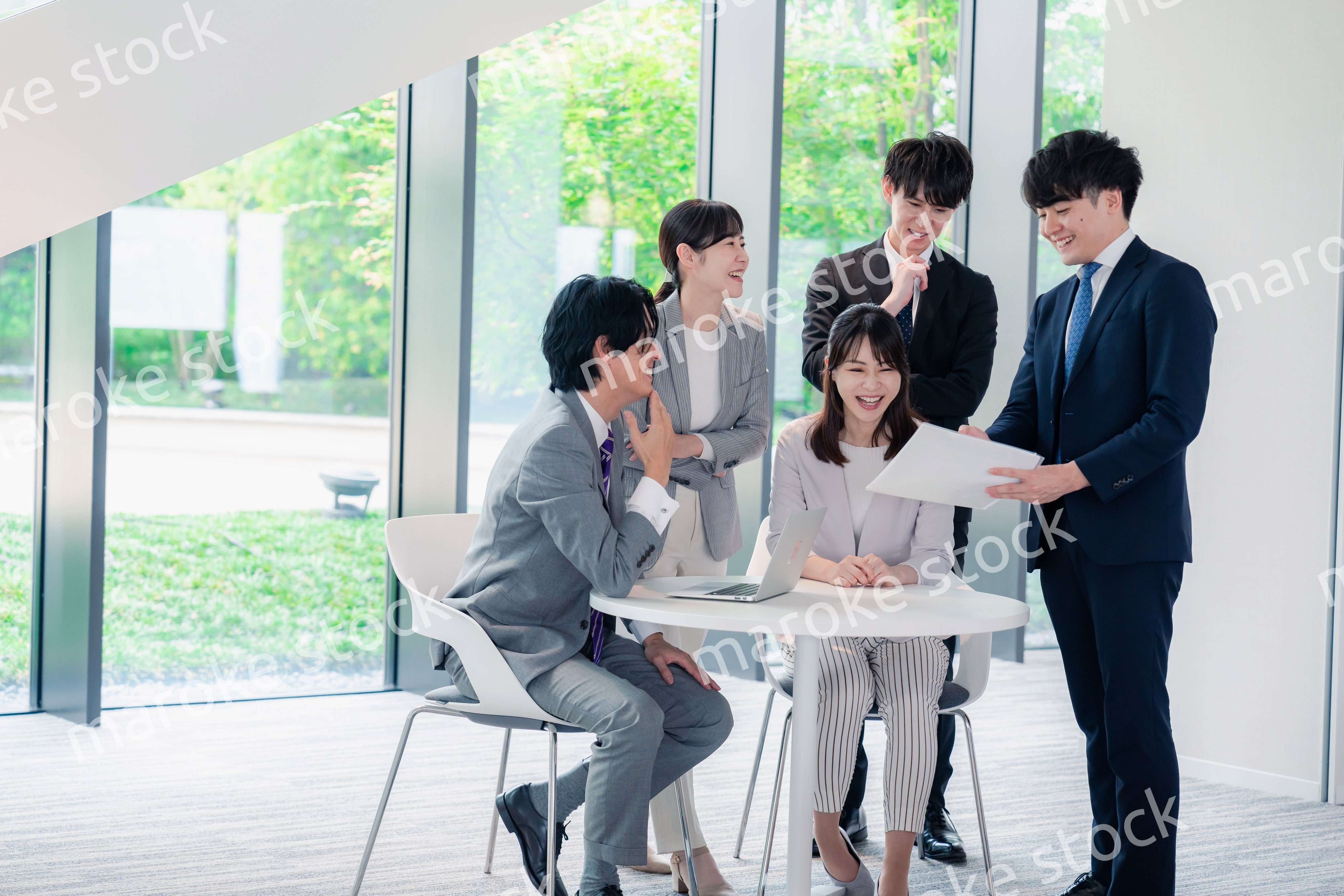 オフィスで笑顔で打ち合わせをするビジネスパーソン