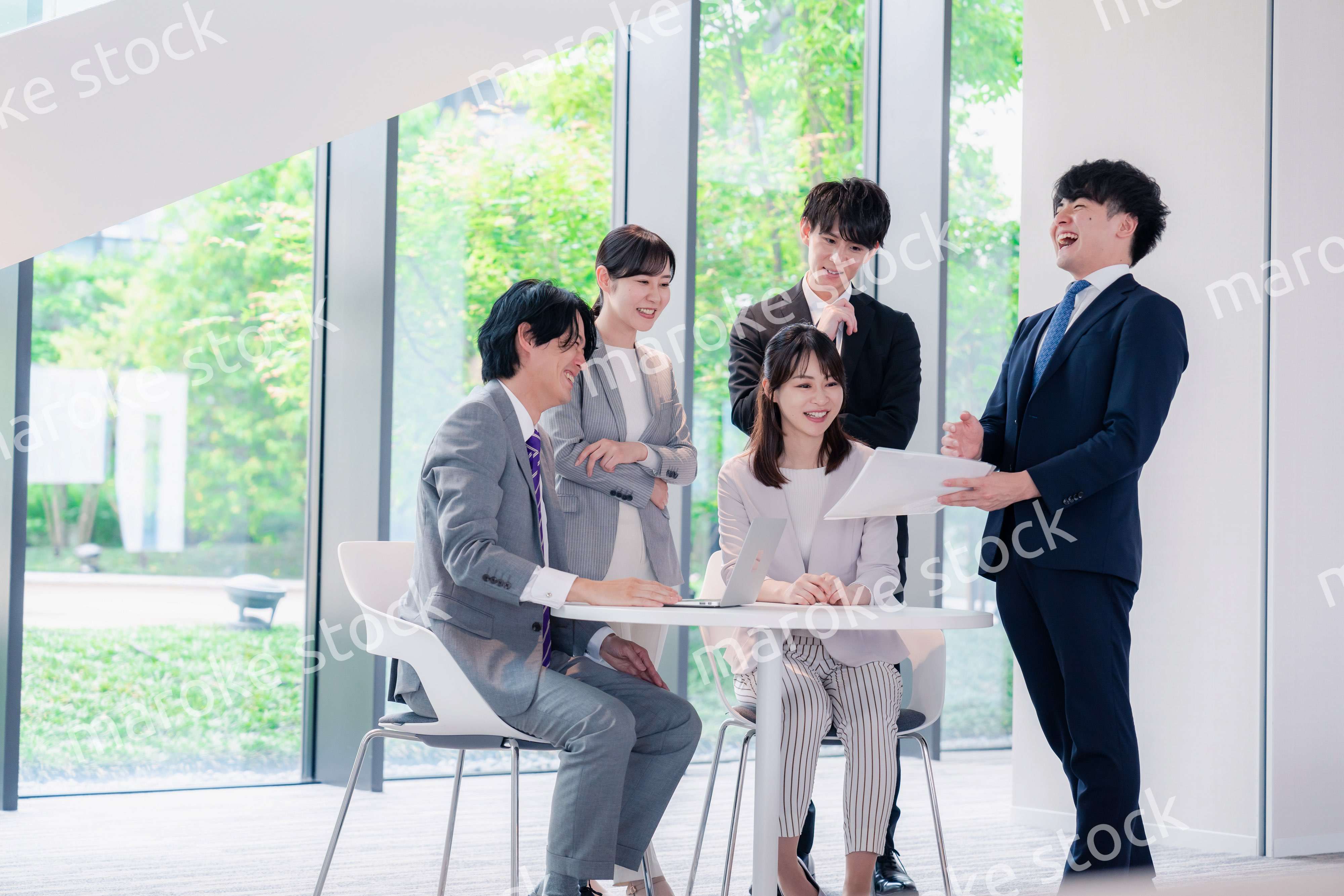 オフィスで笑顔で打ち合わせをするビジネスパーソン